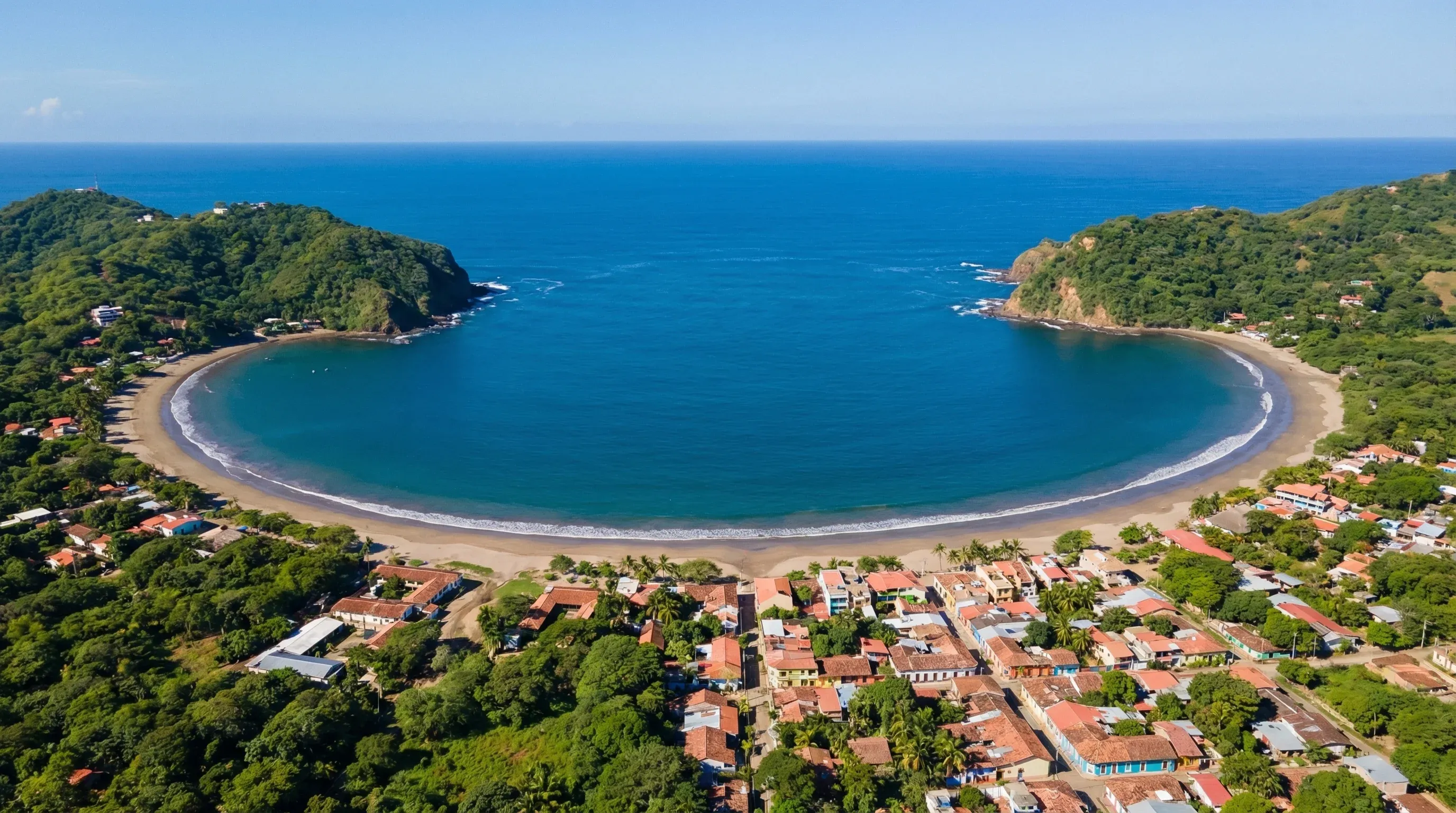 A high-angle view of the crescent-shaped bay and coastal town of San Juan del Sur on the Pacific coast.