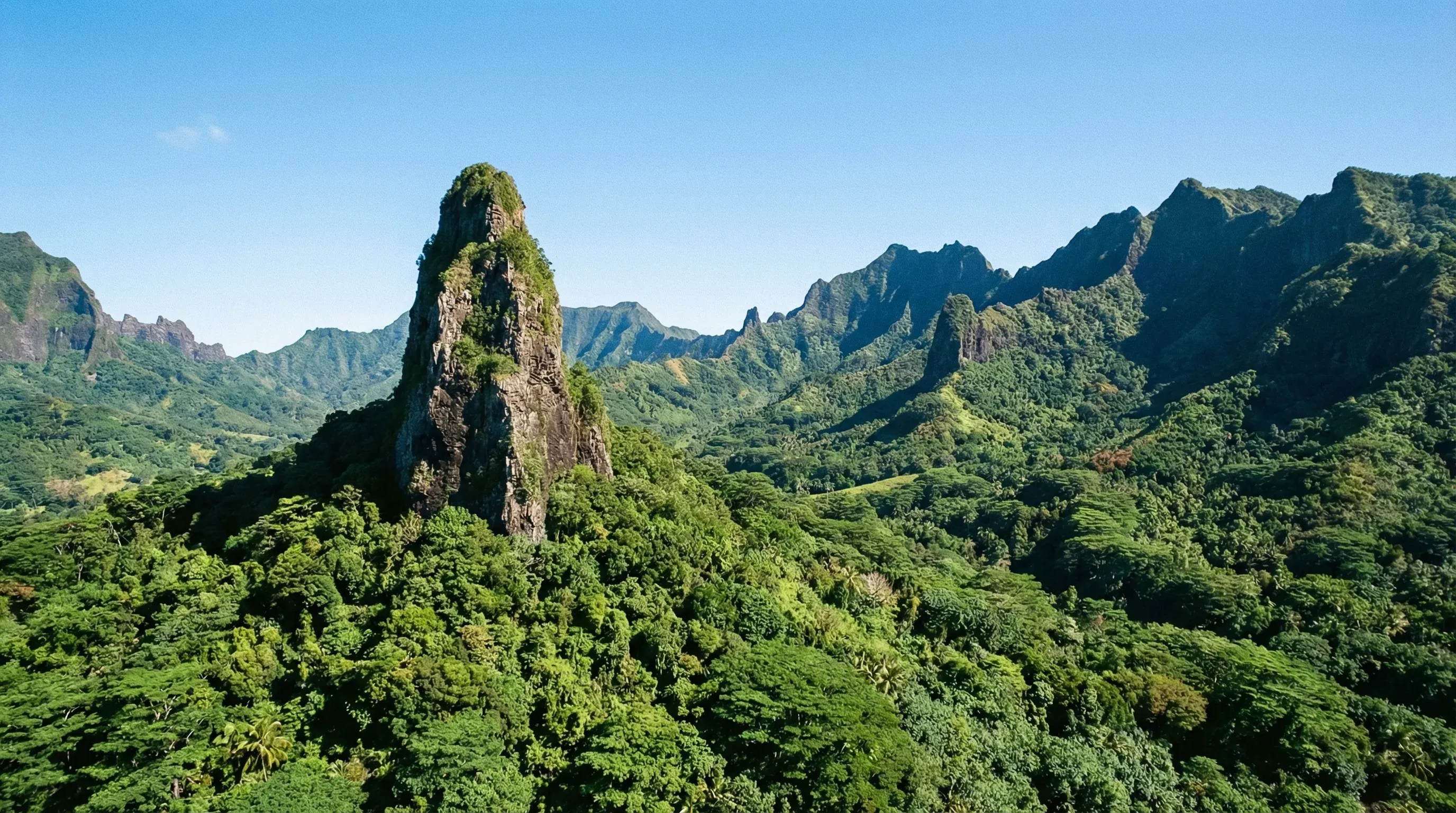 The sharp volcanic peak of Te Rua Manga rising above the dense green tropical rainforest on the island of Rarotonga.