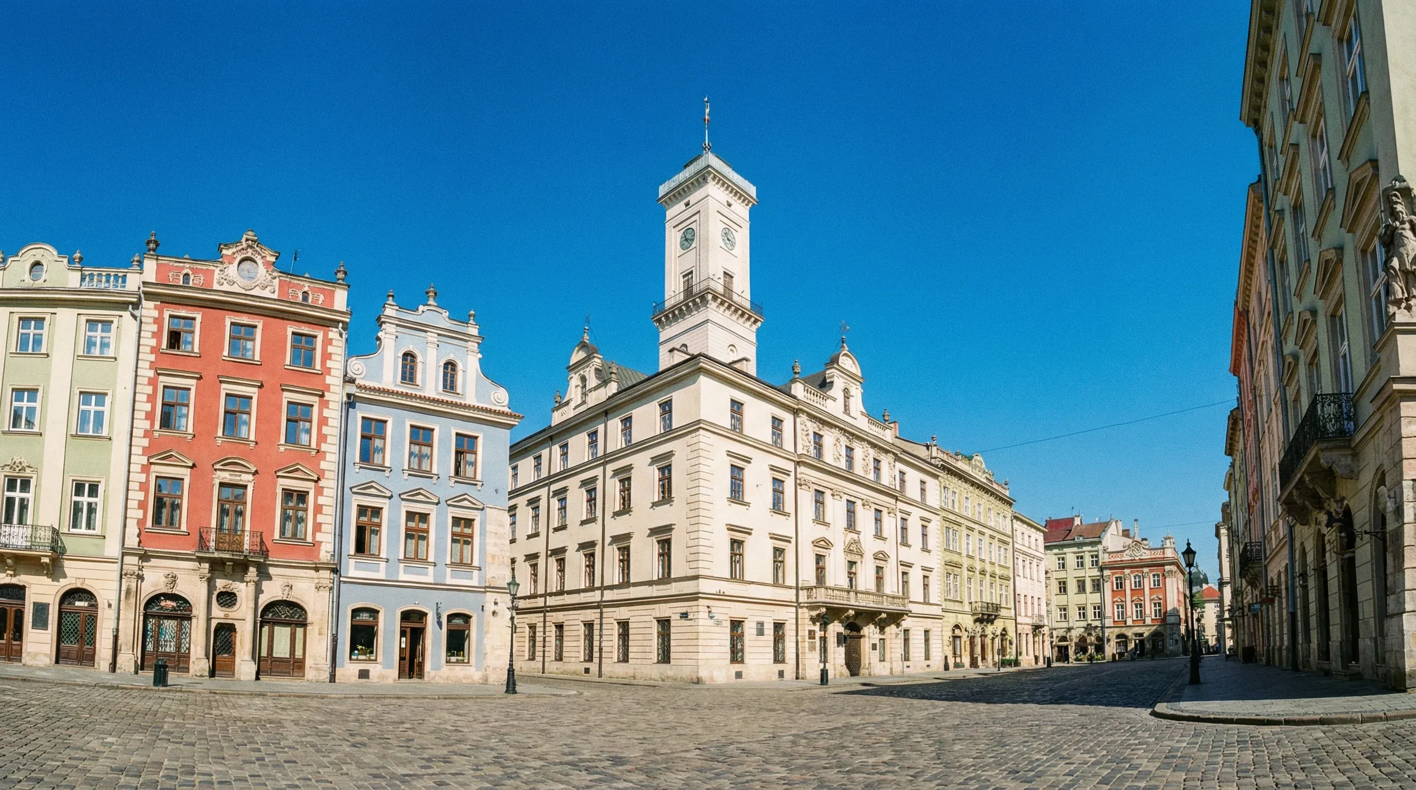 The historic Rynok Square in Lviv featuring the Town Hall tower and colorful old merchant buildings.