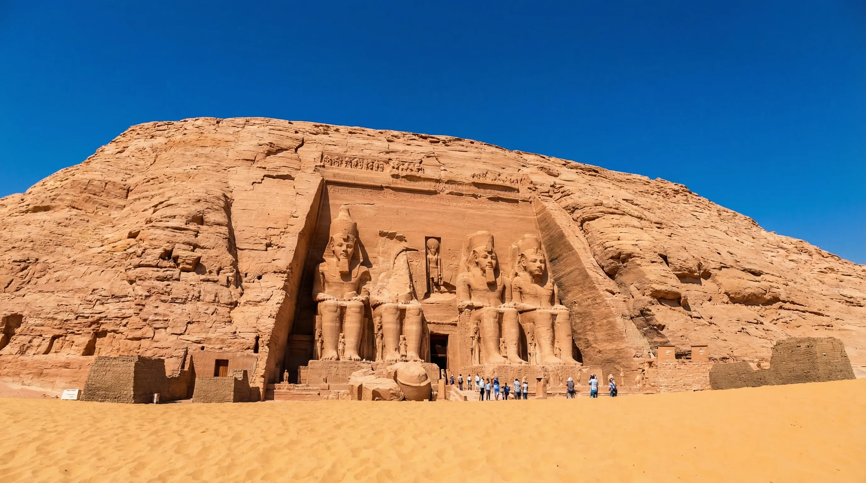 Four colossal seated statues of Pharaoh Ramses II carved into the cliff face at Abu Simbel.