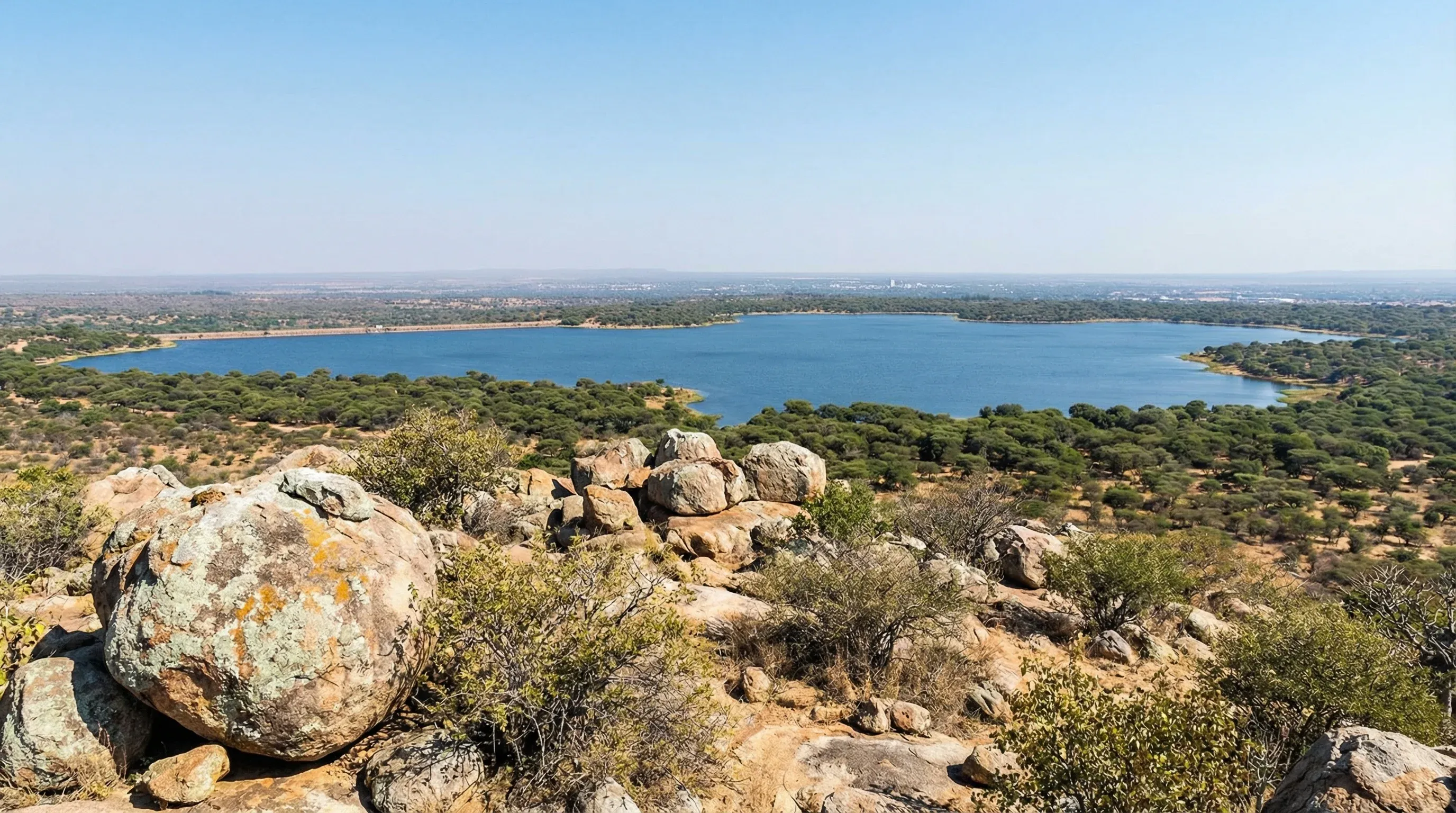 A high-angle view from Kgale Hill showing the Gaborone Dam and the surrounding green savanna in southeastern Botswana.