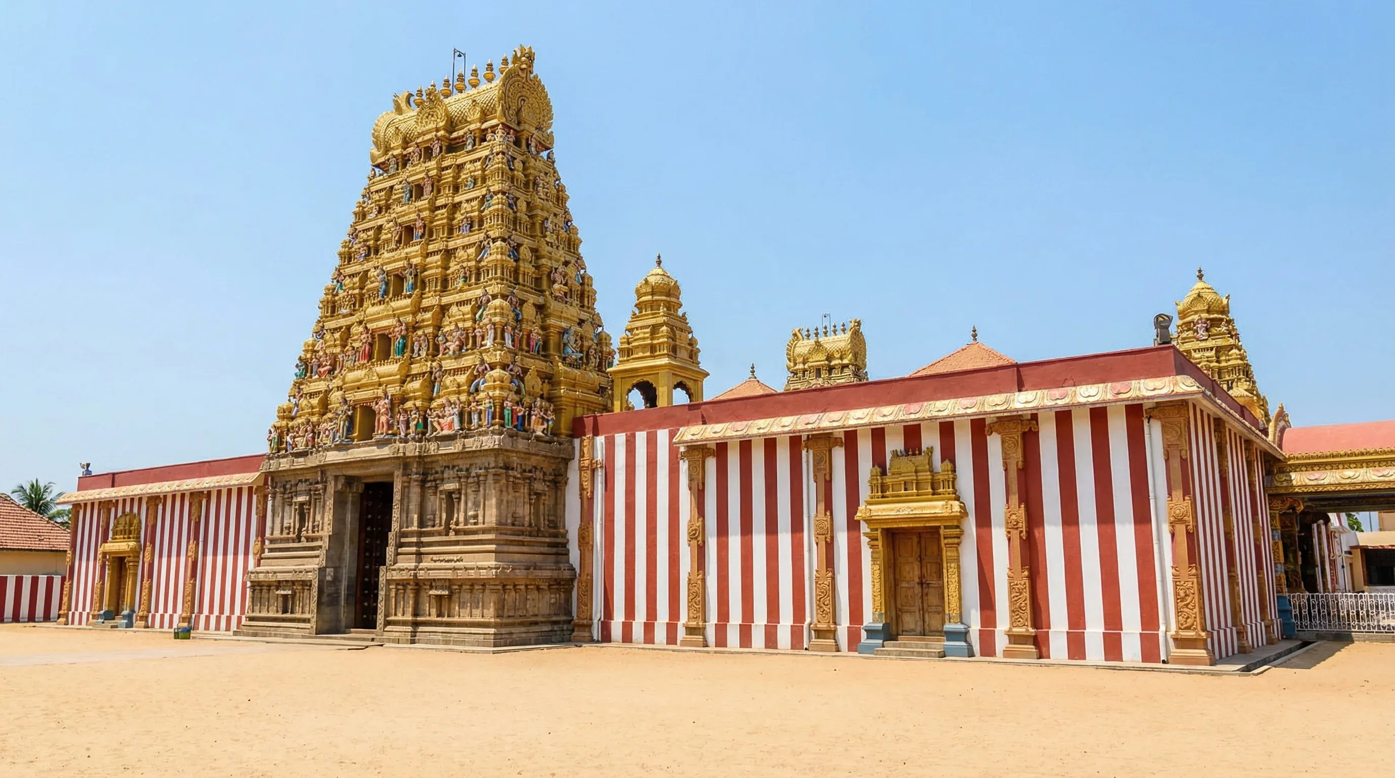 The golden Nallur Kandaswamy Kovil temple with red-and-white striped walls in Jaffna, Sri Lanka.