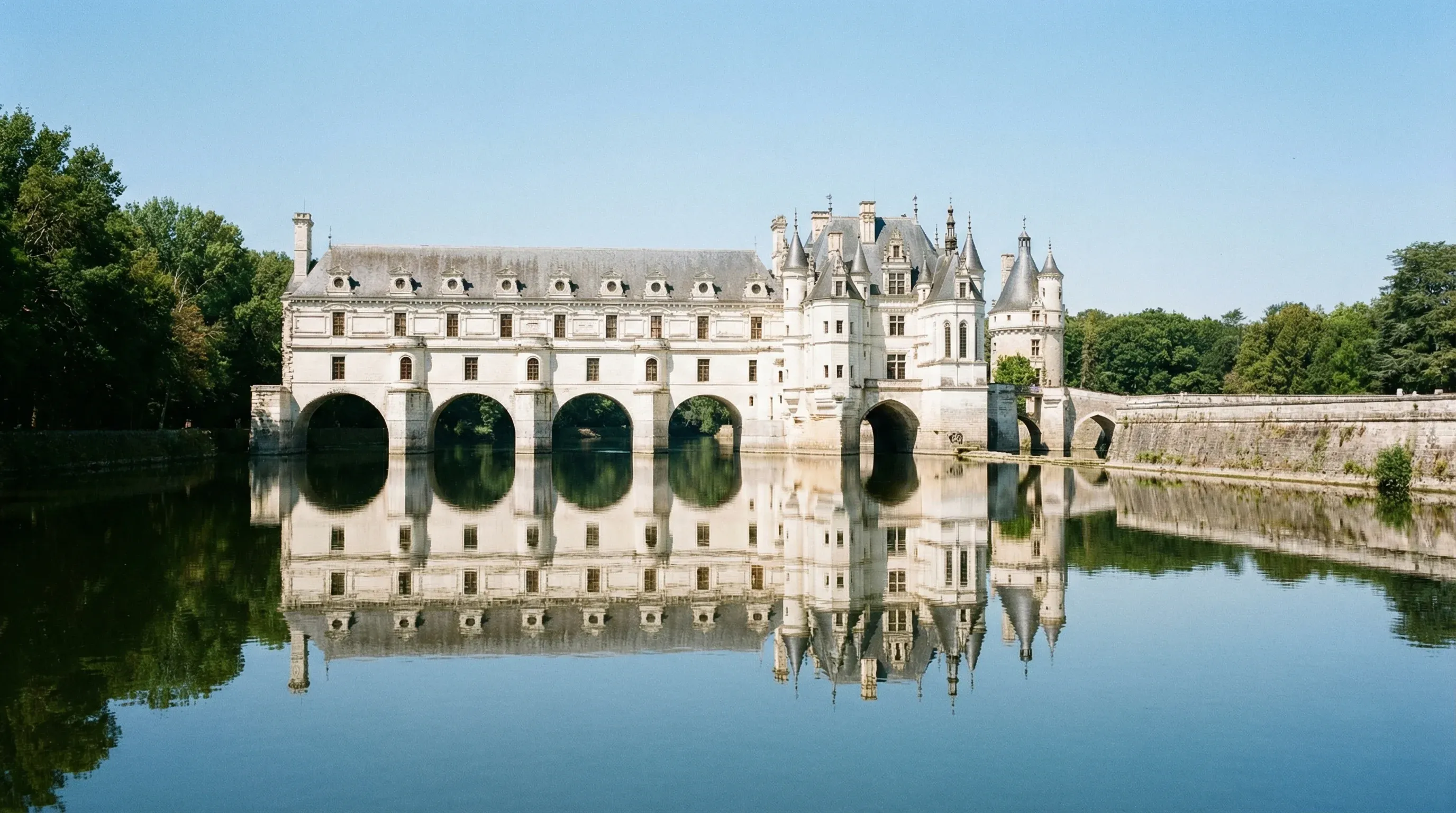 The Renaissance architecture of Château de Chenonceau spanning the Cher River in the Loire Valley, France.