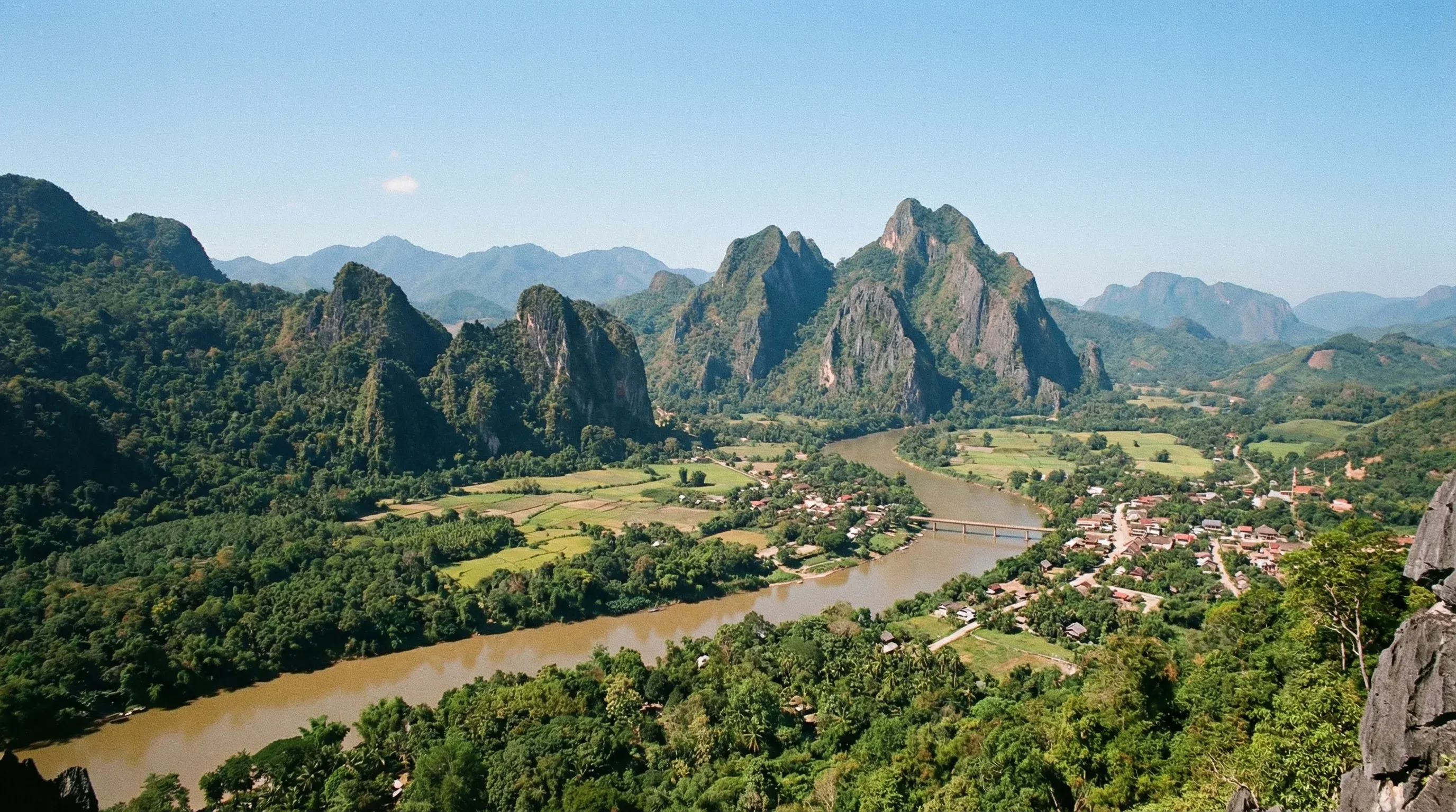 A high-altitude view of the Nam Ou River winding between steep limestone karst mountains in Northern Laos.