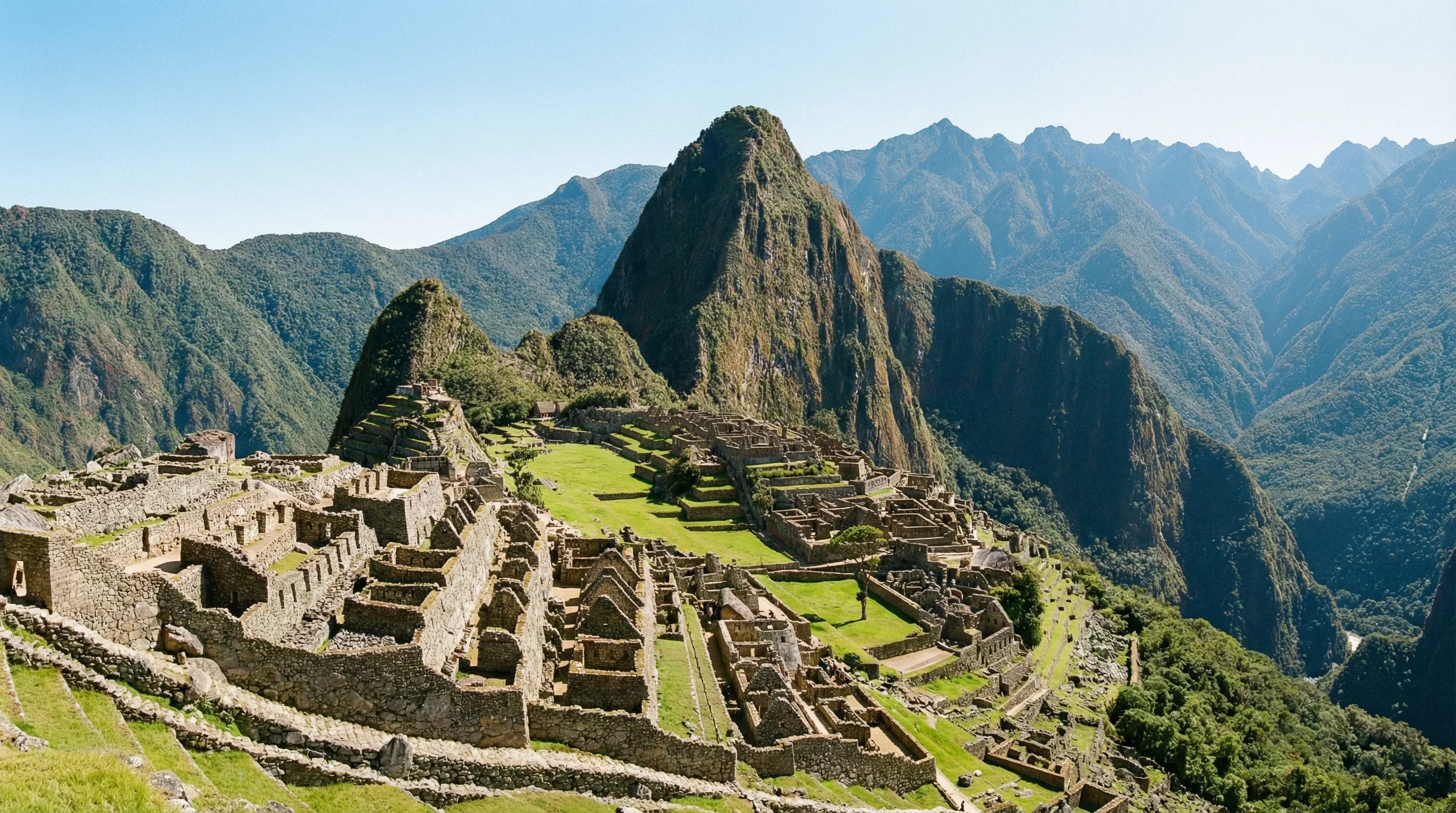 The stone ruins and terraced fields of the Machu Picchu citadel with a large mountain peak in the background.