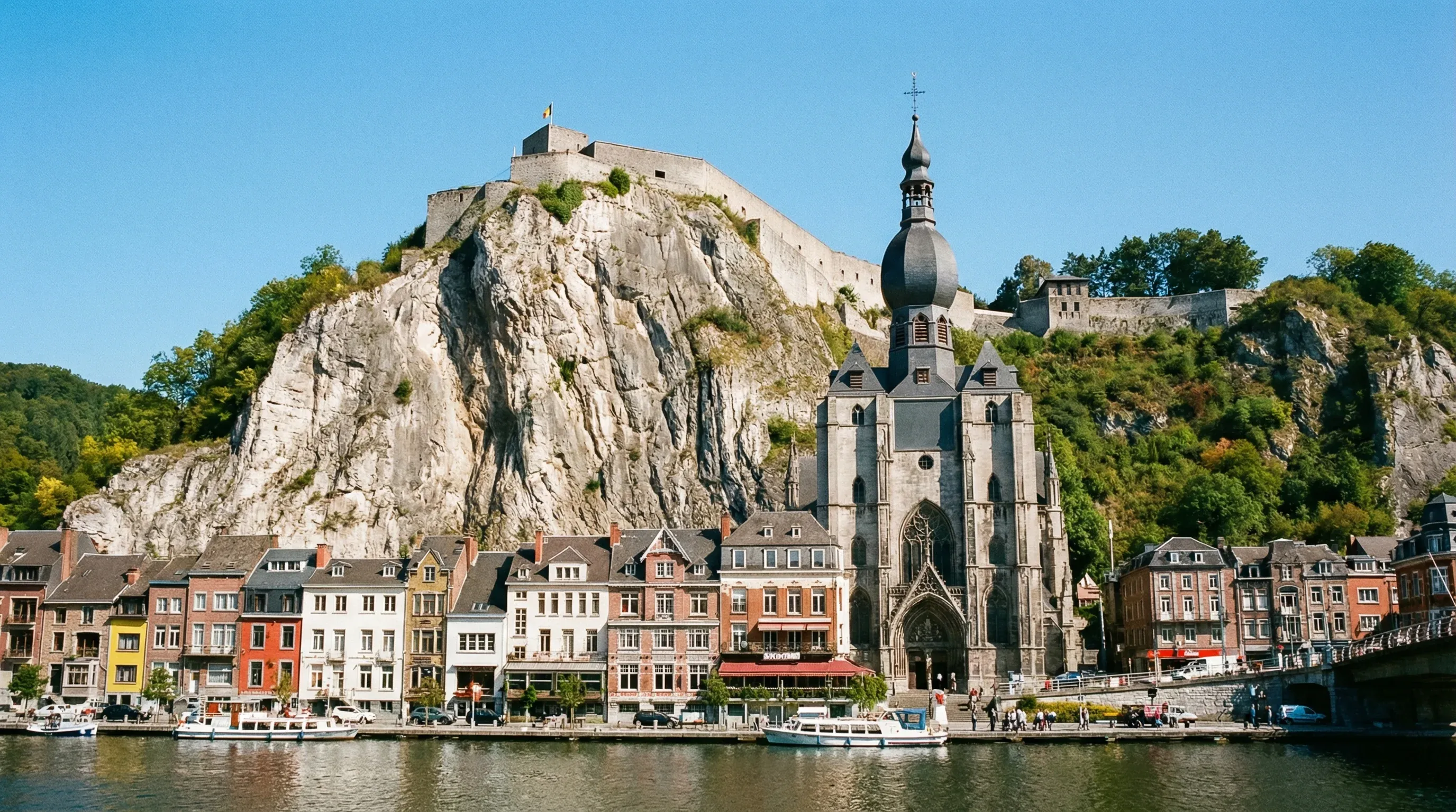 The town of Dinant in Wallonia, showing the Collegiate Church of Notre-Dame and the Citadel perched on a limestone cliff above the Meuse River.