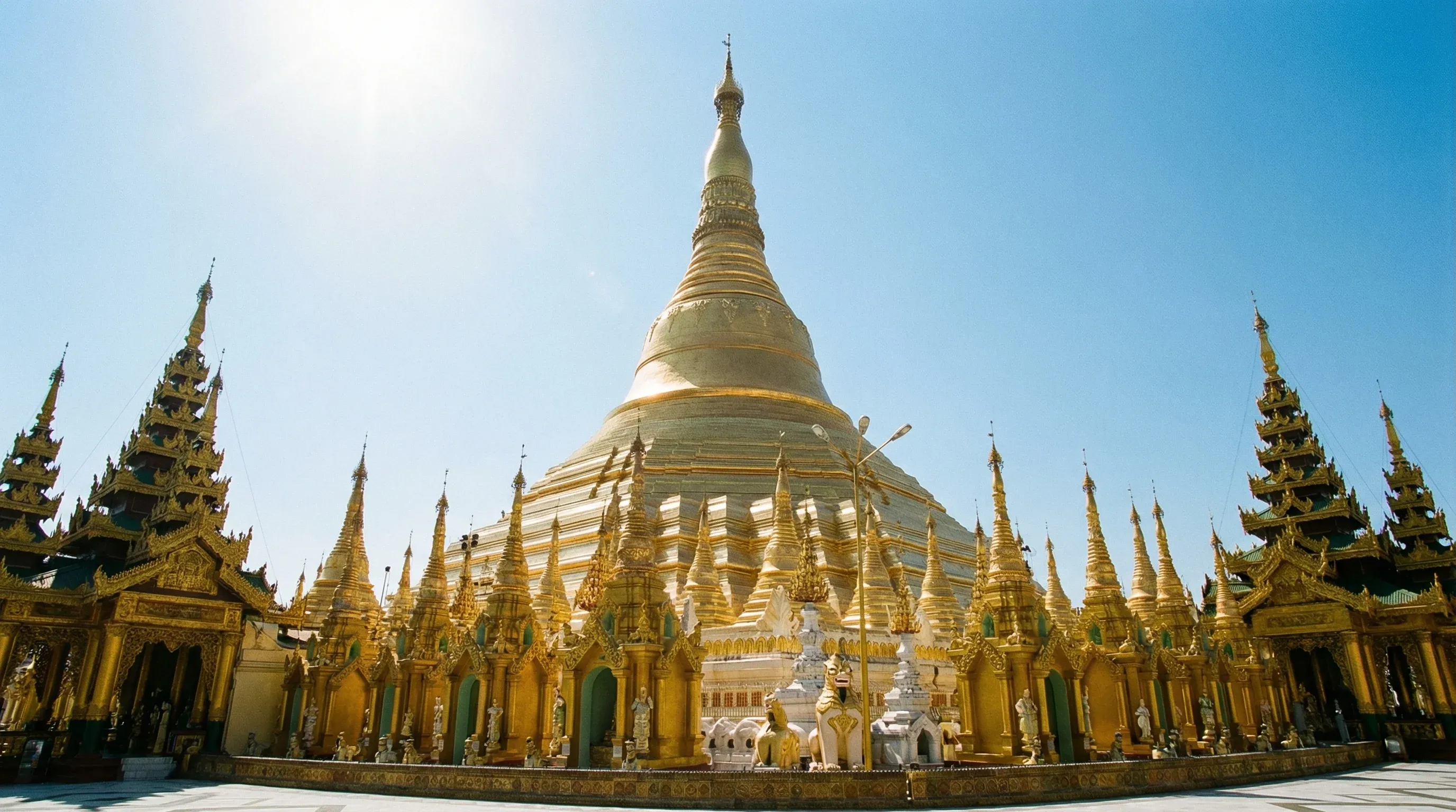 The massive golden stupa of the Shwedagon Pagoda surrounded by smaller ornate shrines in Yangon.