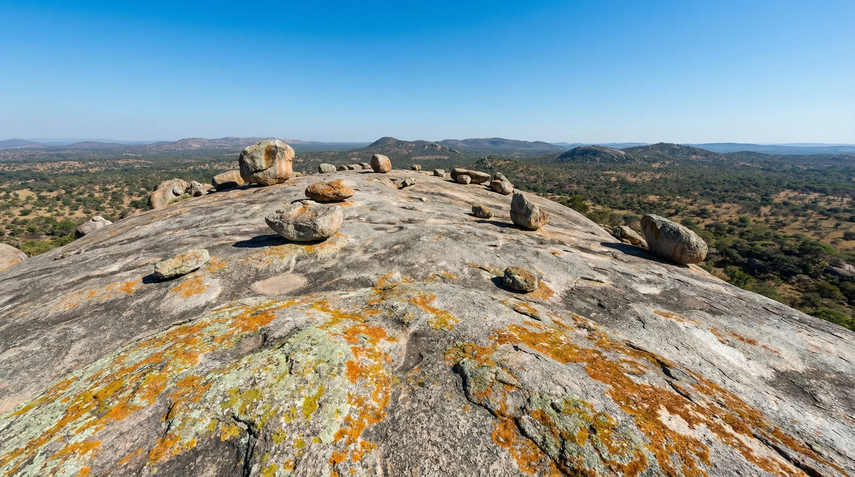 A view from the top of a large granite rock formation looking out over the rural landscape near Harare.
