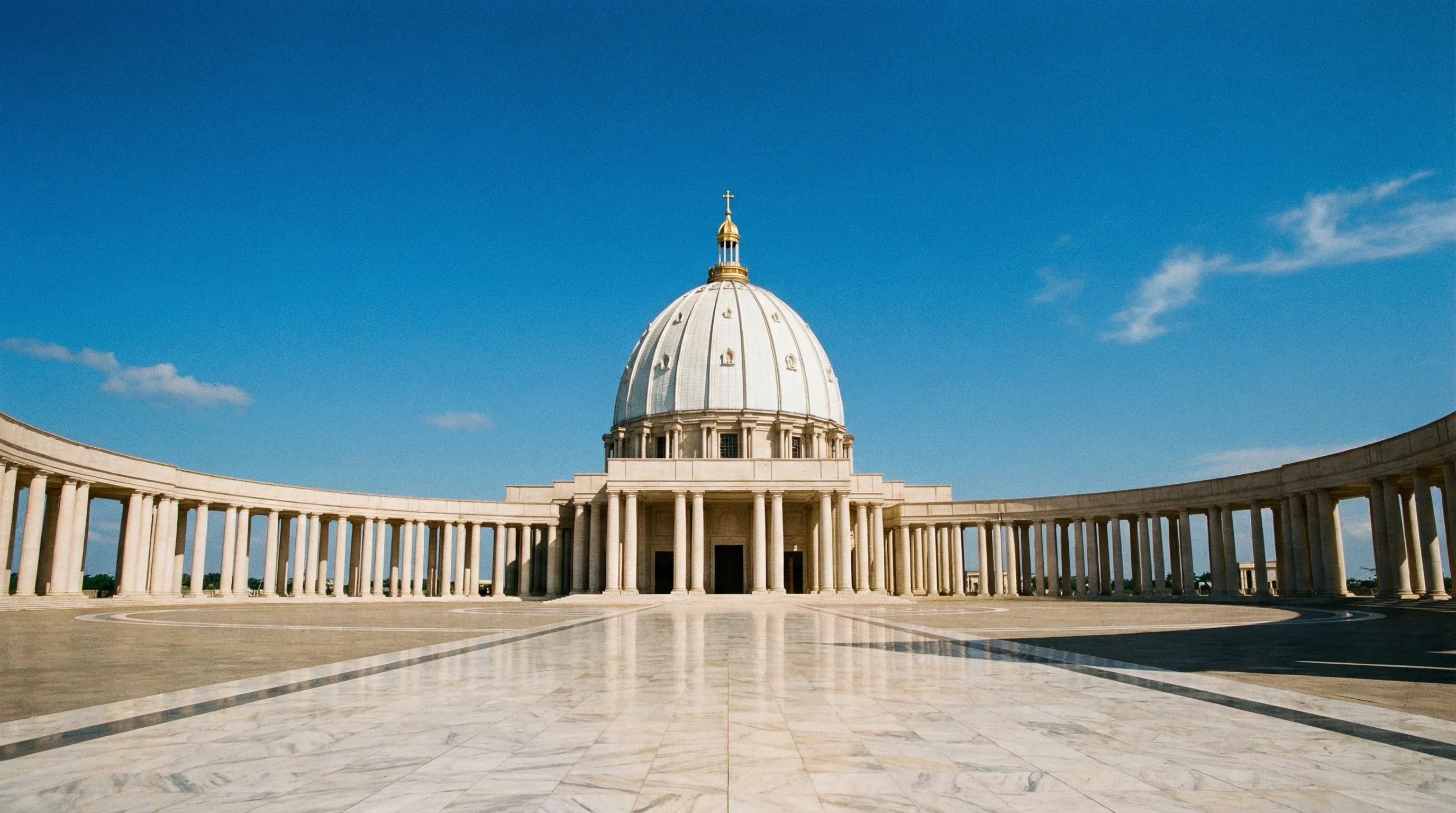 The massive Basilica of Our Lady of Peace in Yamoussoukro showing its central dome and grand marble colonnade.
