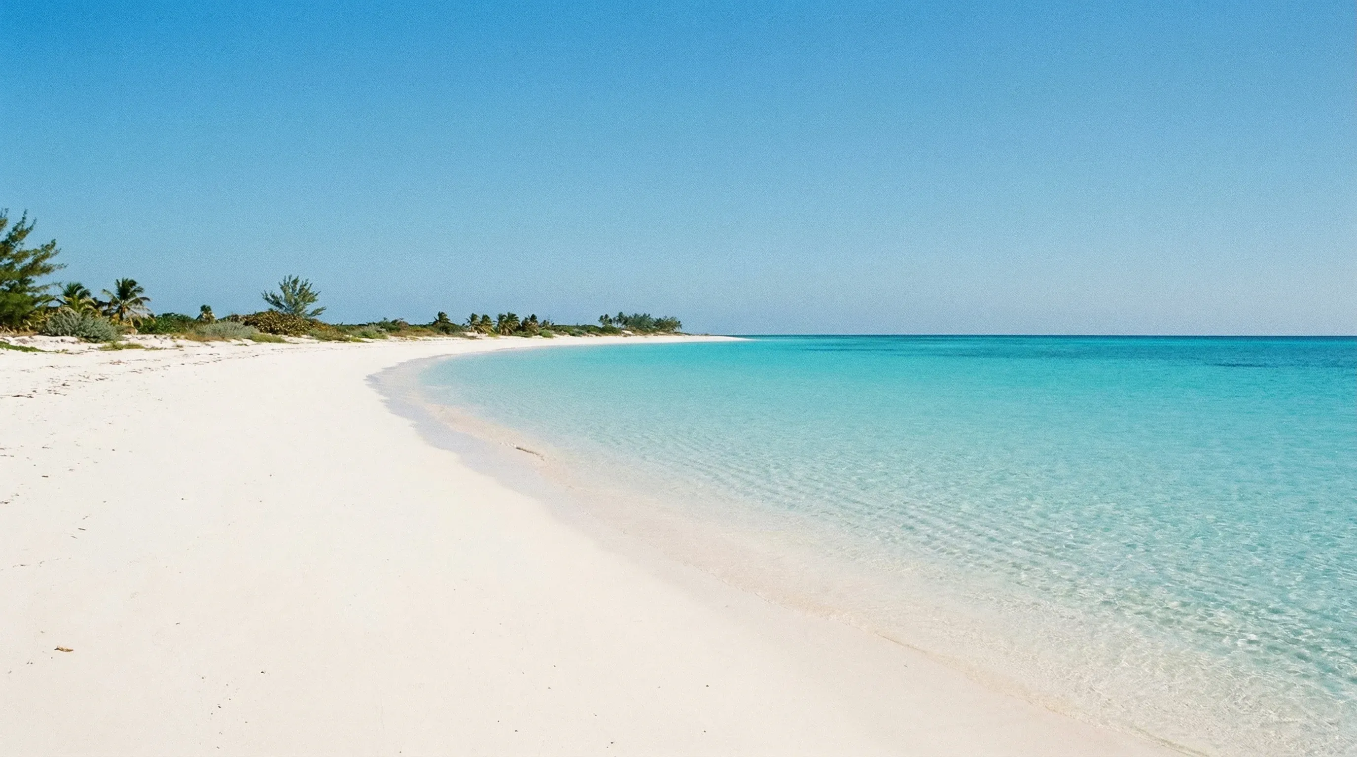 A wide white sand beach and turquoise water at Playa Sirena on Cayo Largo del Sur, Cuba.