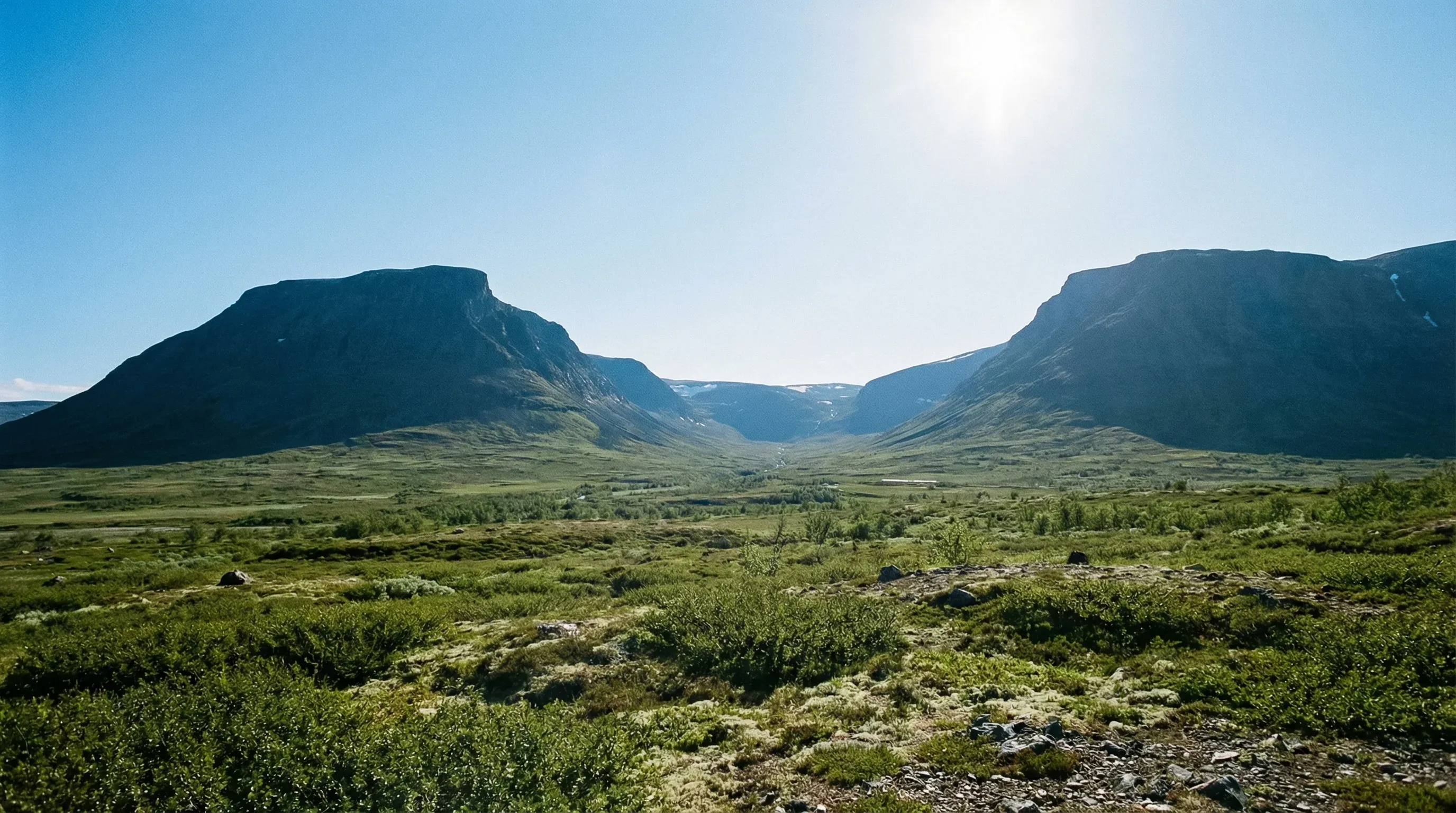 The iconic U-shaped valley of Lapporten in Abisko National Park under a bright midday sky.