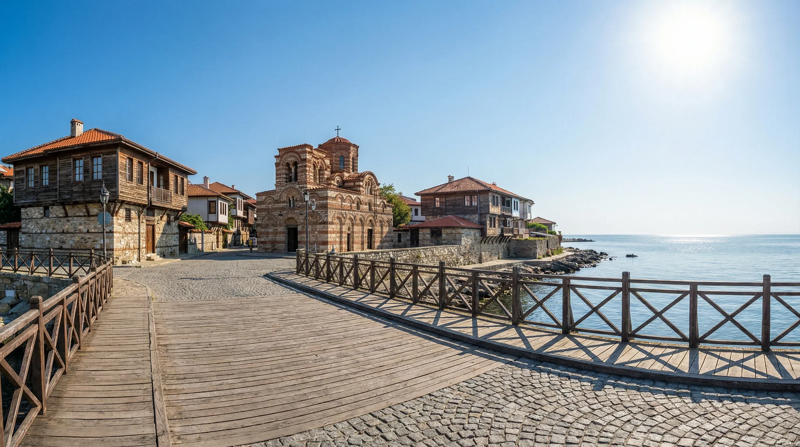 A wide-angle view of the historic Old Town of Nessebar, Bulgaria, featuring traditional wooden houses and ancient stone architecture against the Black Sea.