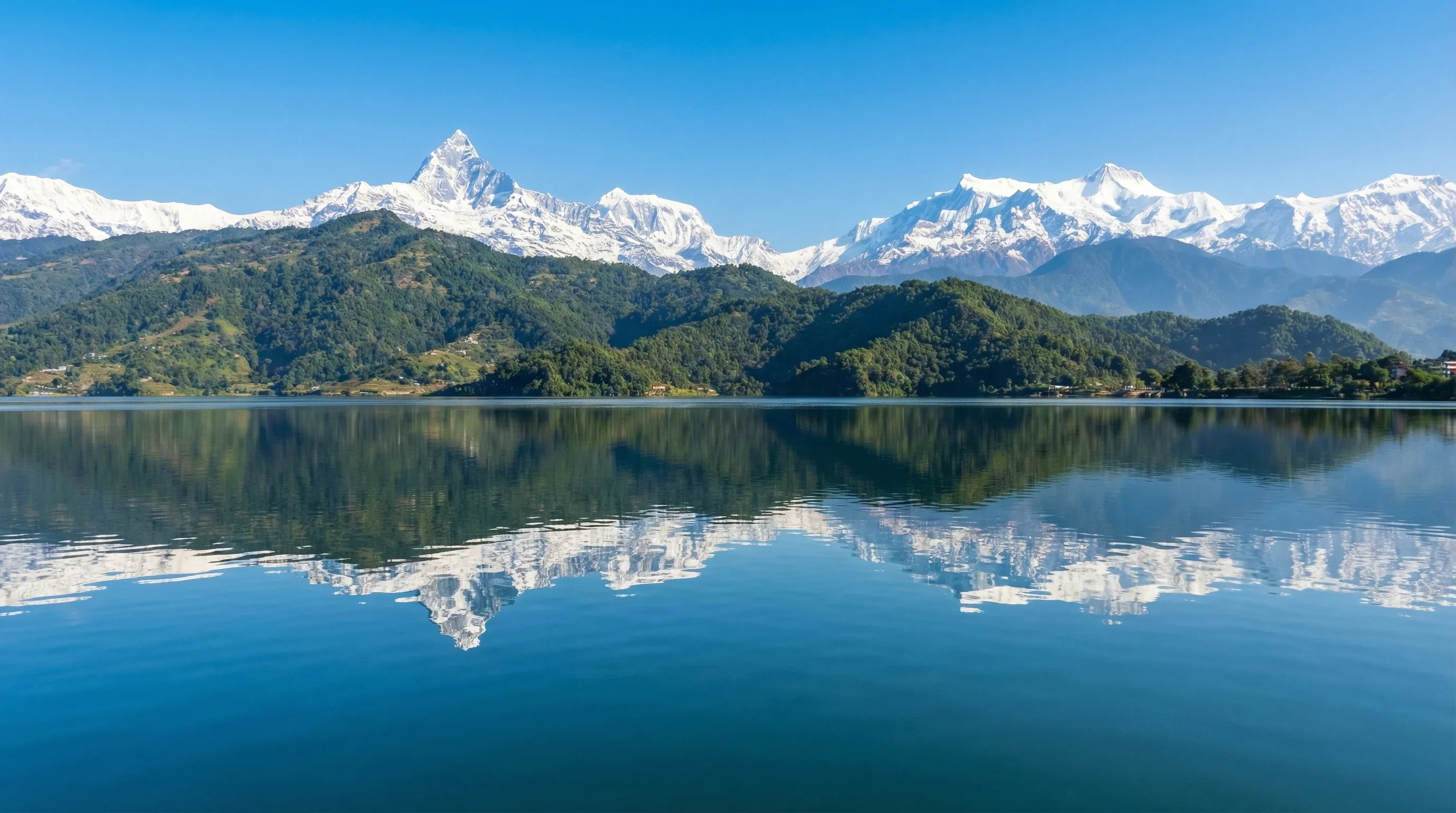 Phewa Lake in Pokhara with the reflection of the snow-capped Machhapuchhre mountain peak in the background.