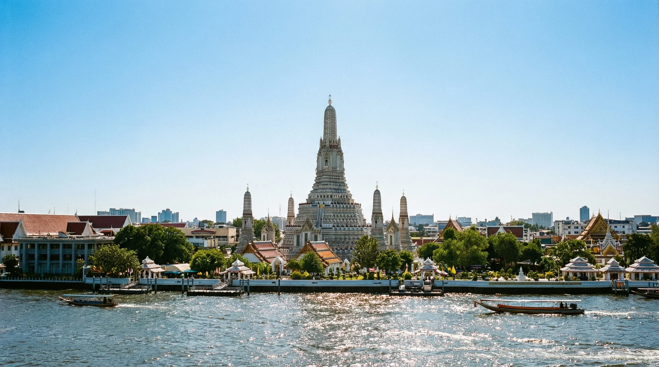 The central prang of Wat Arun temple on the banks of the Chao Phraya River in Bangkok during the day.