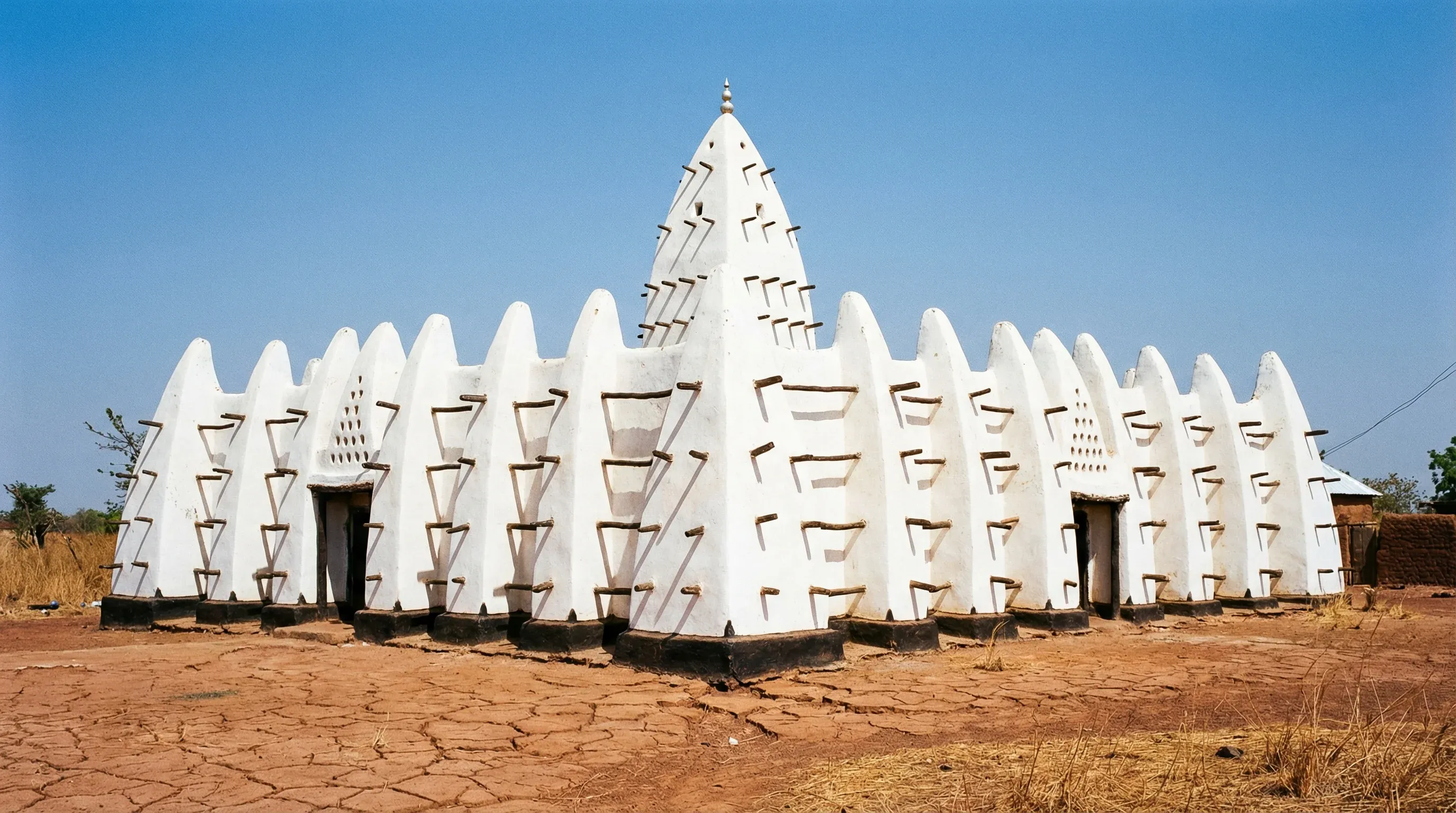 The Larabanga Mosque in Northern Ghana, featuring distinctive white mud walls and dark wooden beams.
