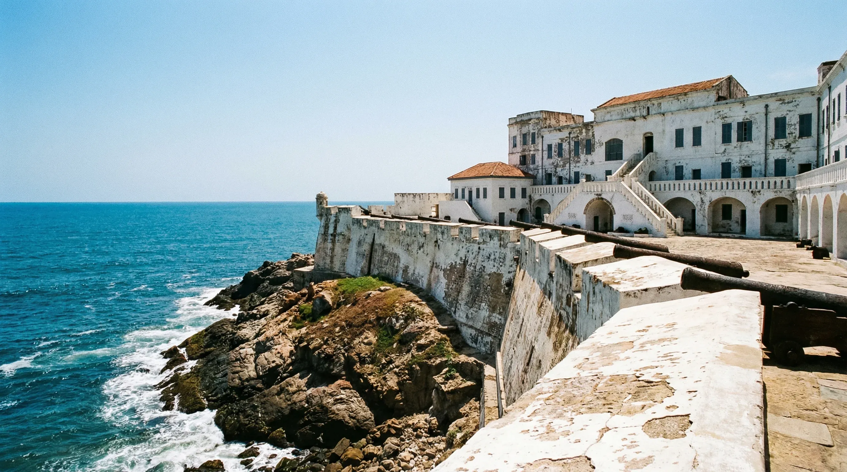 The whitewashed walls and stone ramparts of Cape Coast Castle facing the Atlantic Ocean in Ghana.