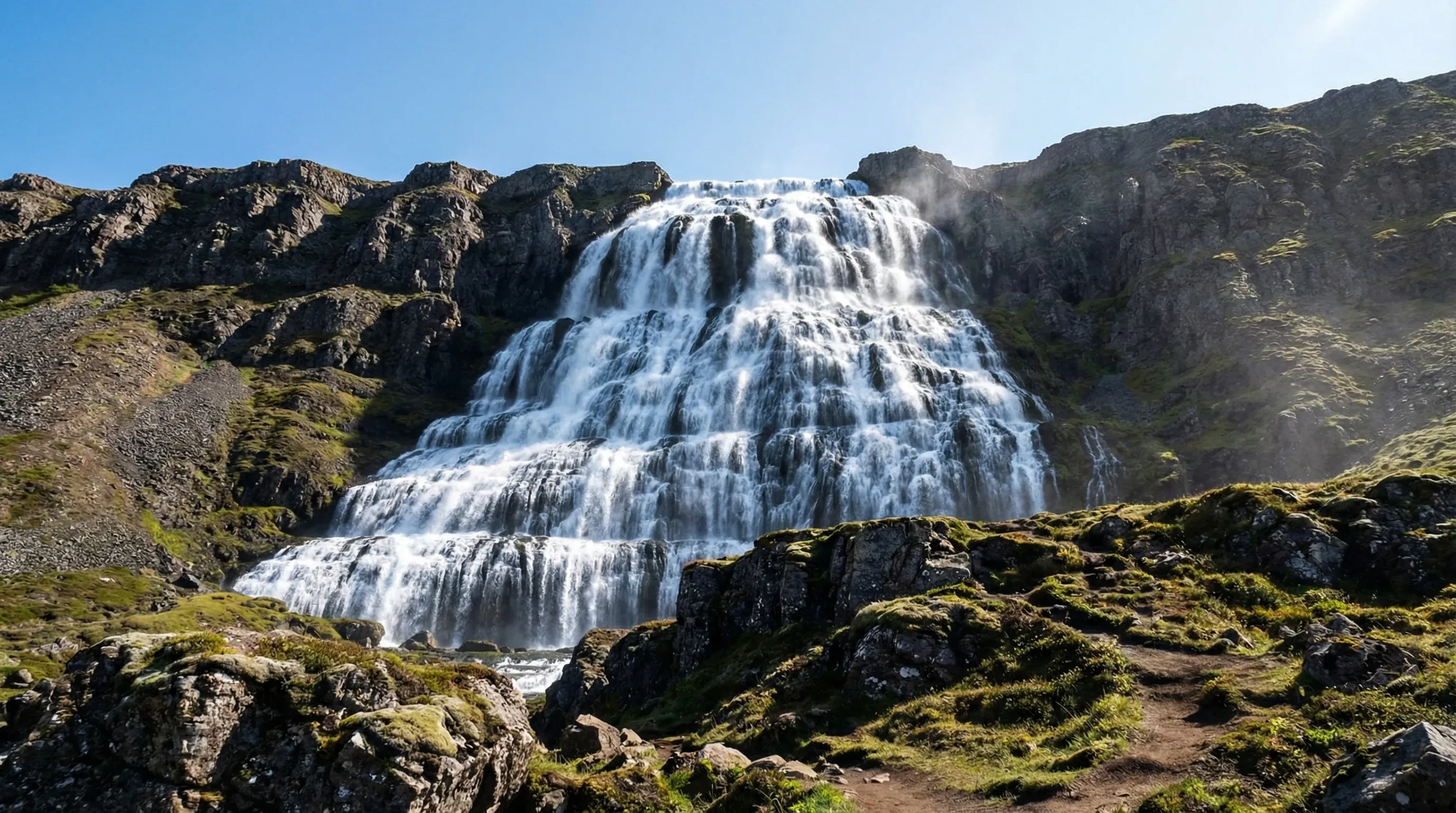 The large, tiered Dynjandi waterfall cascading down a cliffside in the remote Westfjords region of Iceland.