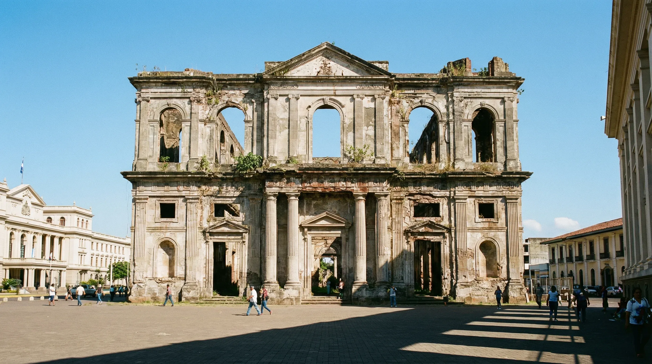 The ruins of the Old Cathedral of Managua in Plaza de la Revolución under a bright blue sky.