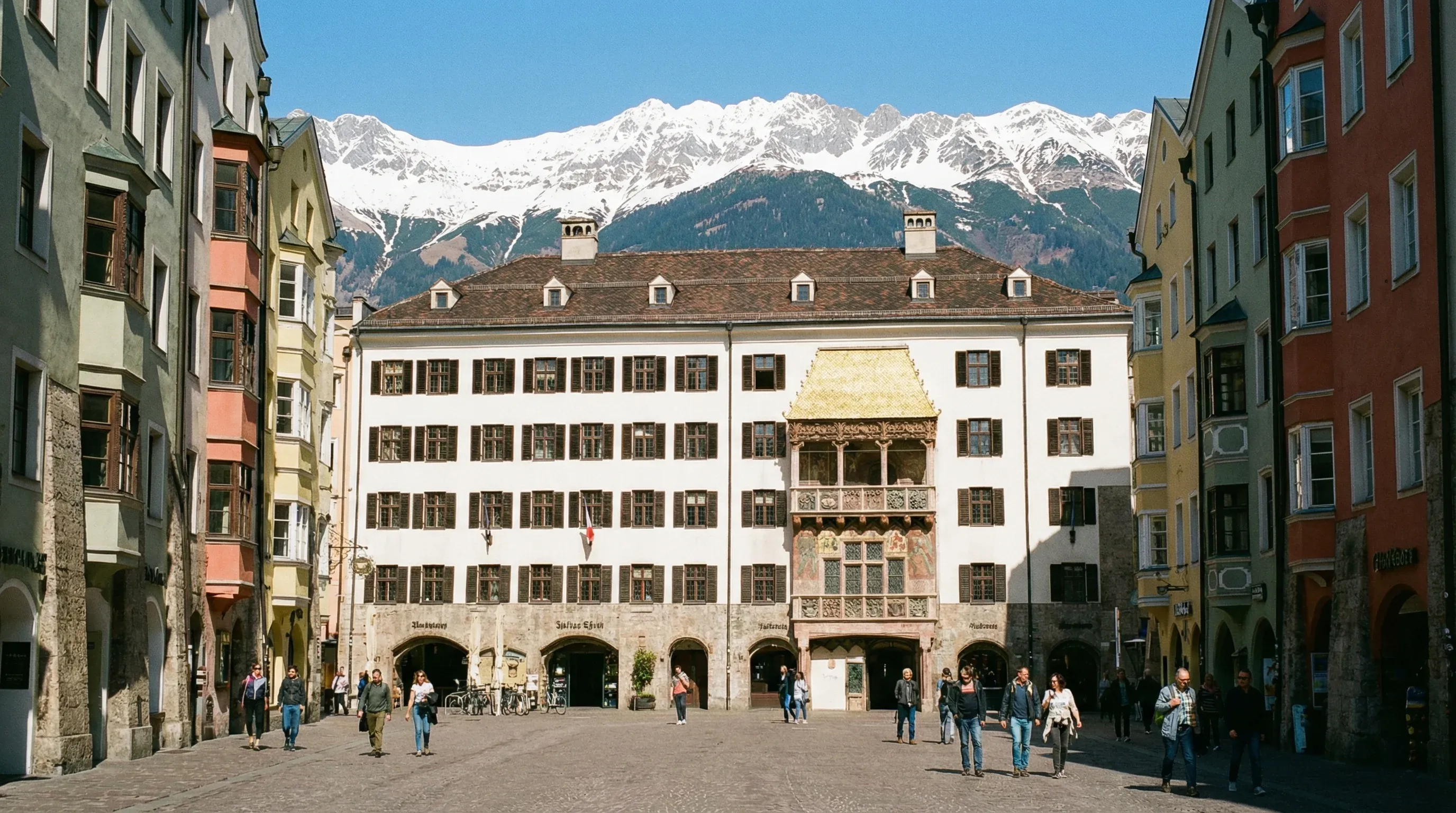 The Goldenes Dachl balcony in Innsbruck with its gilded tiles, situated in front of the snow-capped Nordkette mountain range.