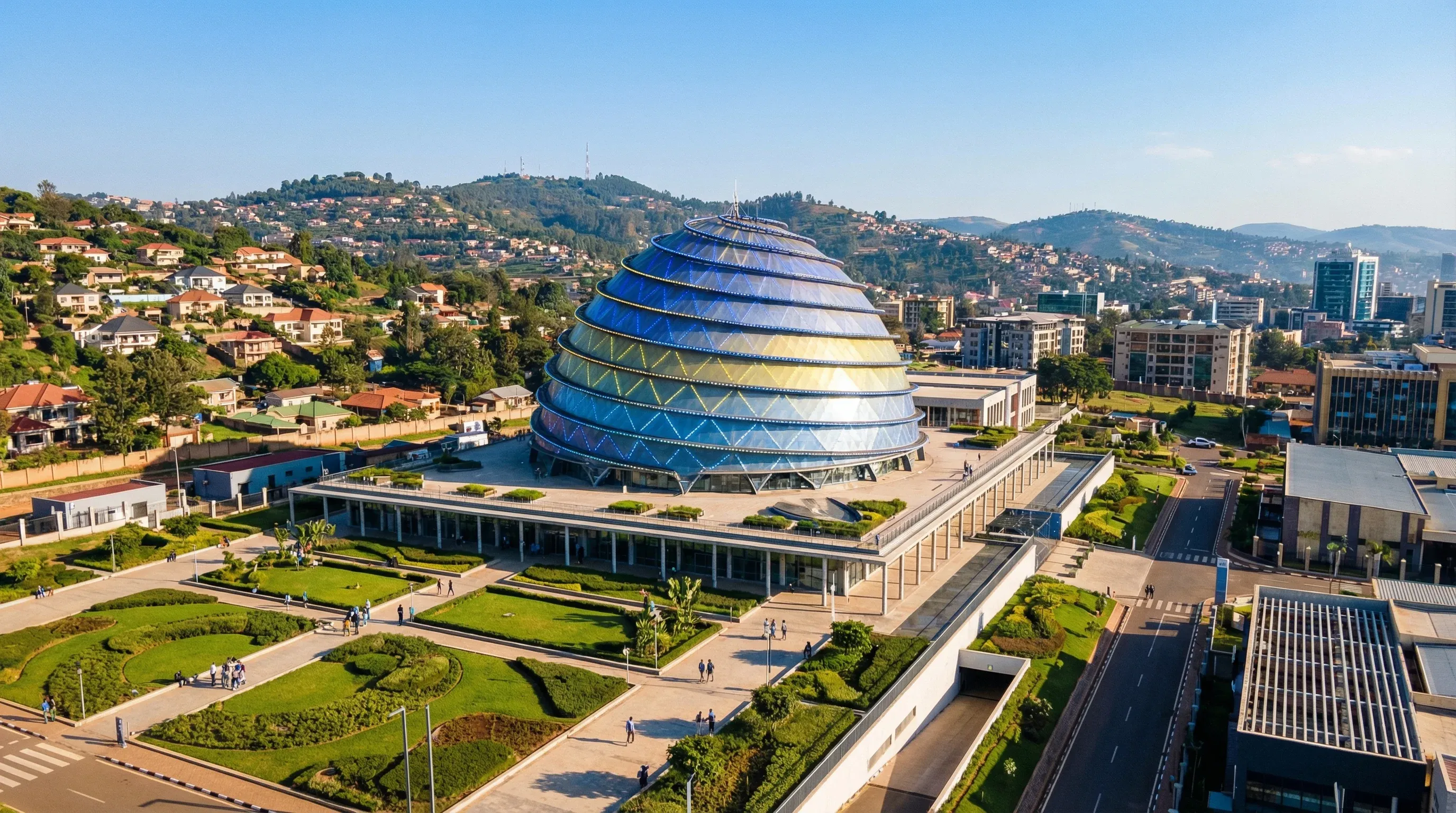 The modern dome of the Kigali Convention Centre surrounded by green gardens and the rolling hills of Kigali city.