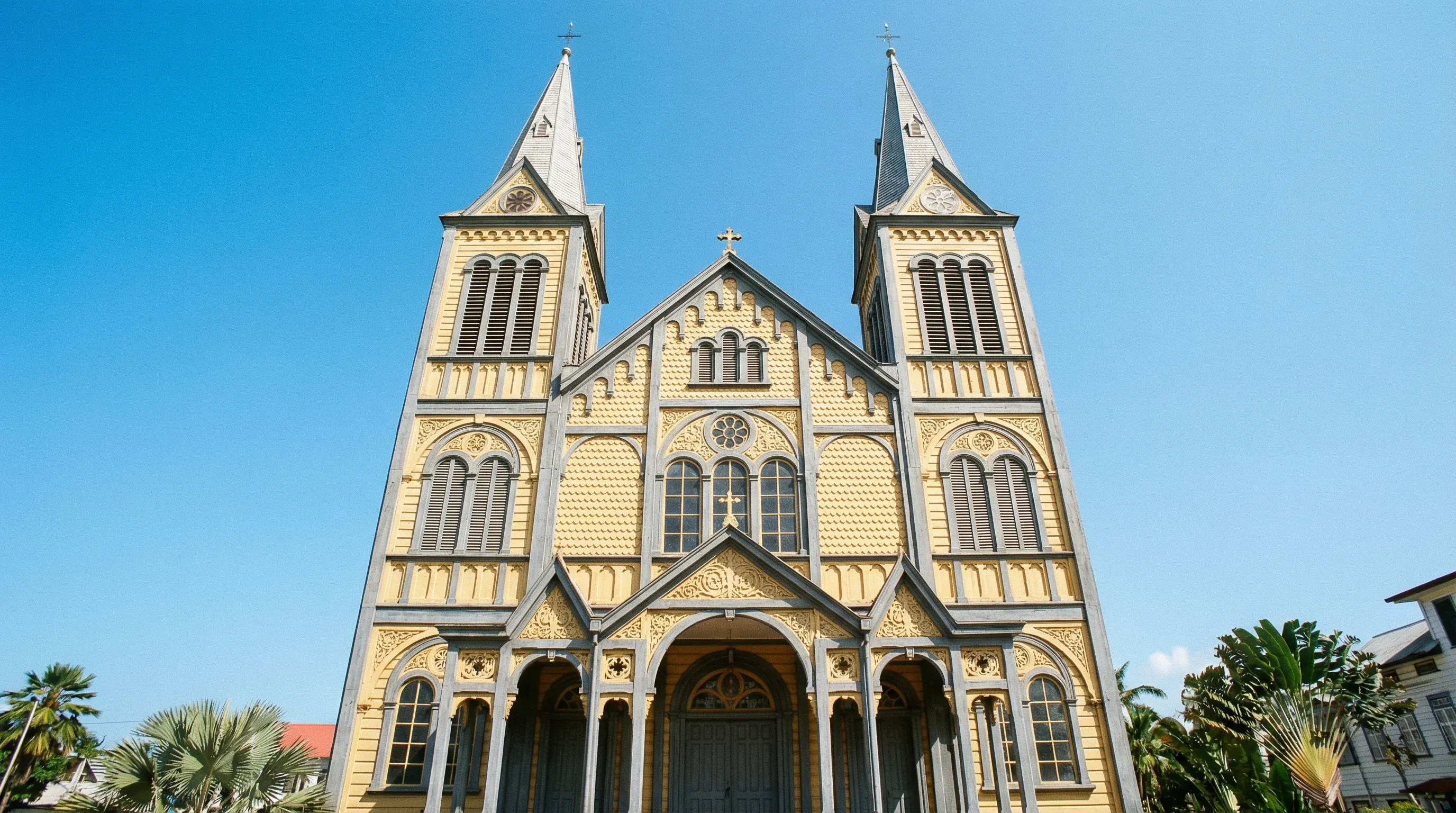 The yellow and grey wooden facade of the Saint Peter and Paul Cathedral-Basilica in Paramaribo, Suriname.