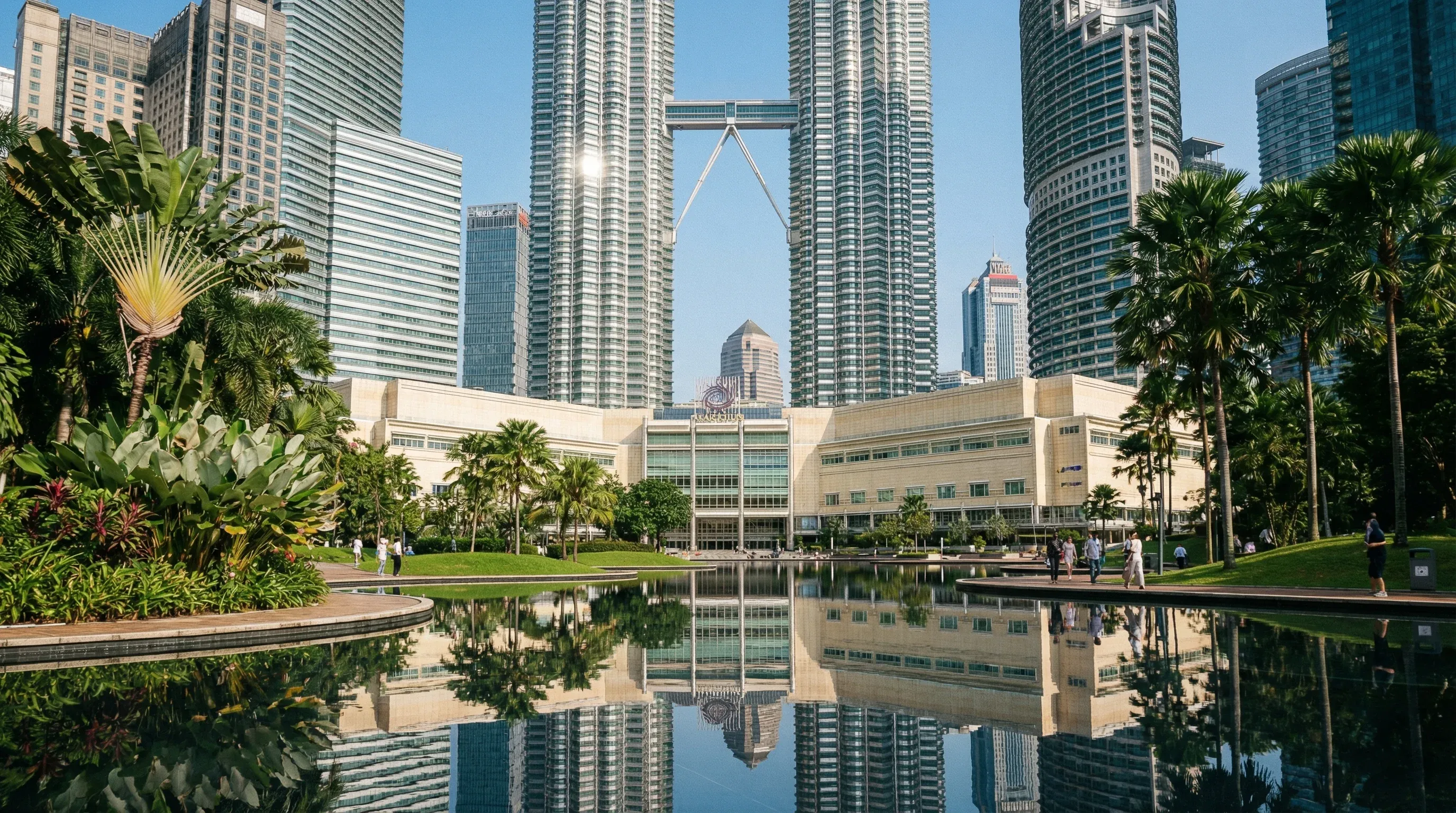 The silver Petronas Twin Towers rising above the tropical greenery of KLCC Park in Kuala Lumpur on a clear day.