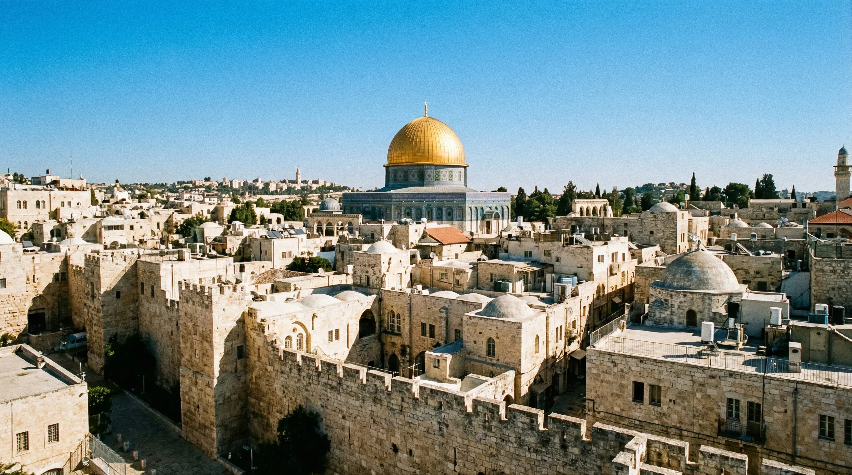 High-angle panoramic view of the Old City of Jerusalem featuring the golden Dome of the Rock and ancient city walls.