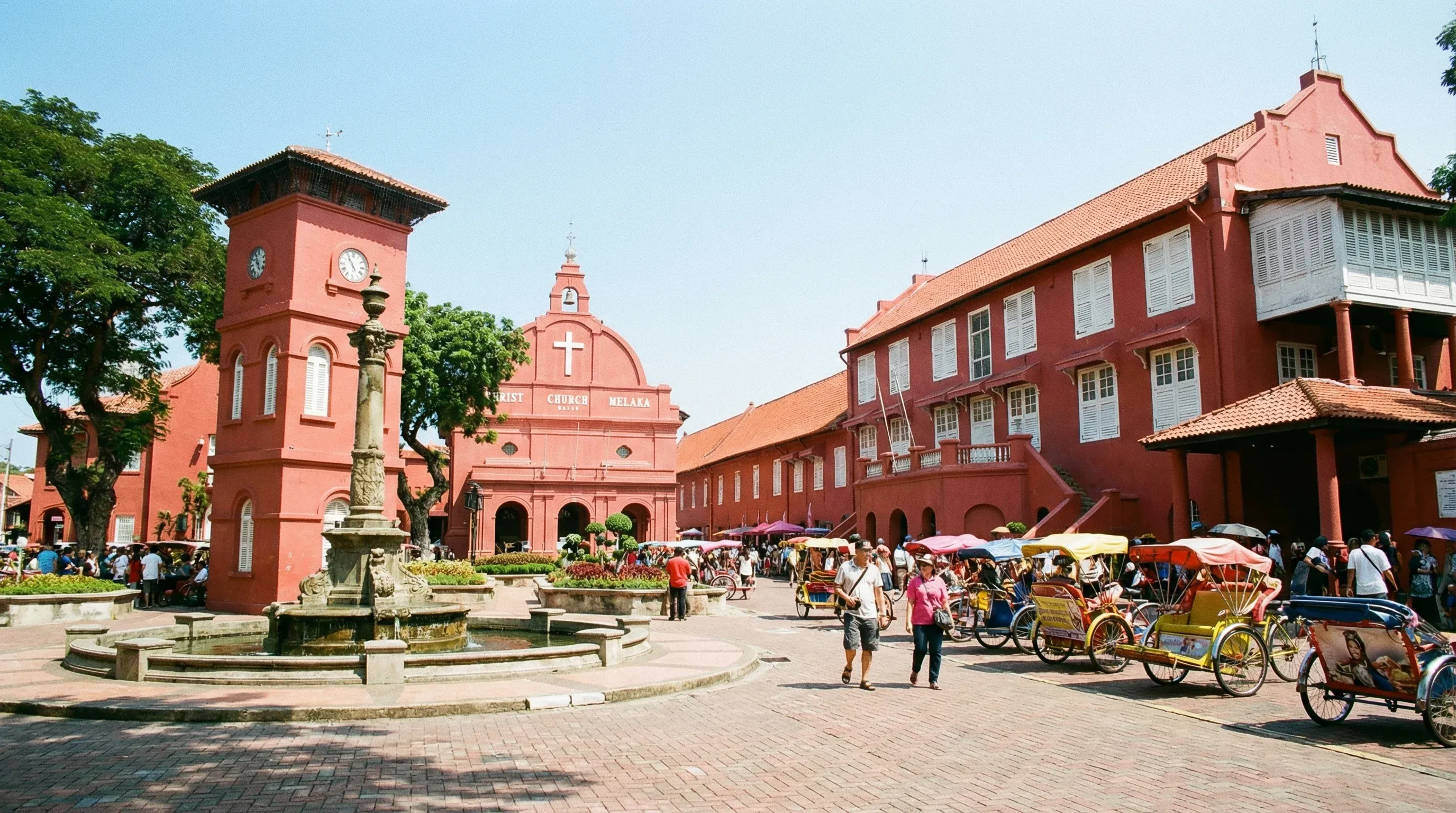 The historic red-walled colonial buildings and Christ Church Melaka in the Dutch Square of Malacca under a bright sun.