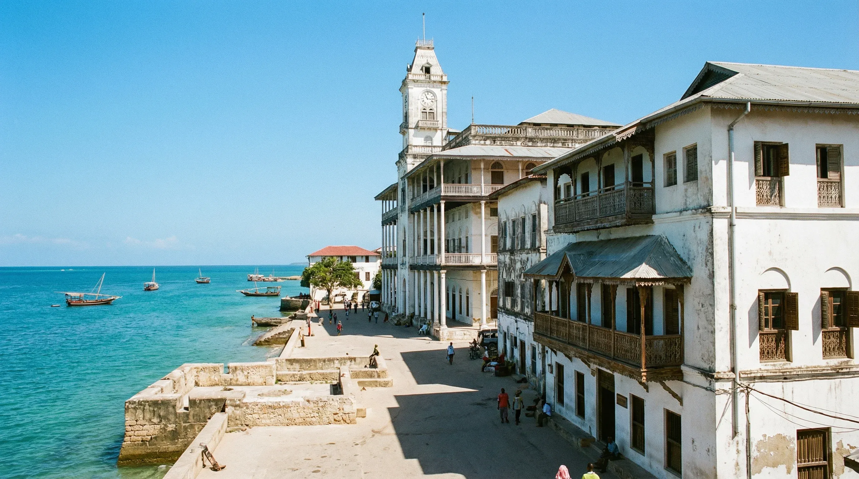 Architectural view of the Stone Town waterfront in Zanzibar featuring coral stone buildings and the ocean.