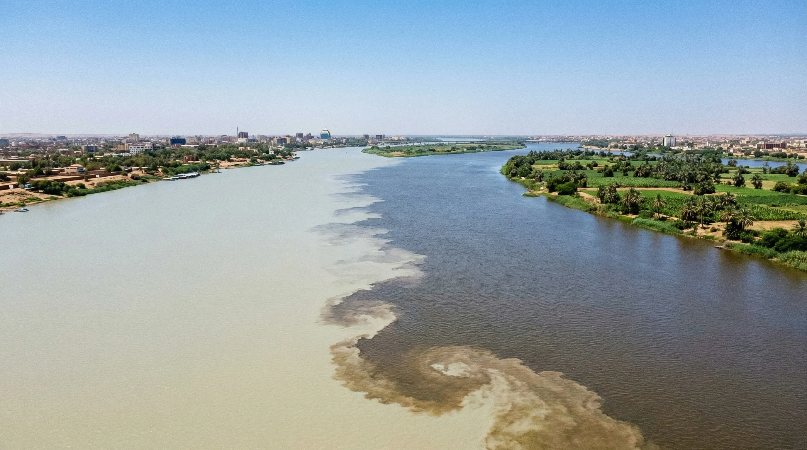 High-angle view of the confluence of the White Nile and Blue Nile rivers, showing the distinct water colors meeting.