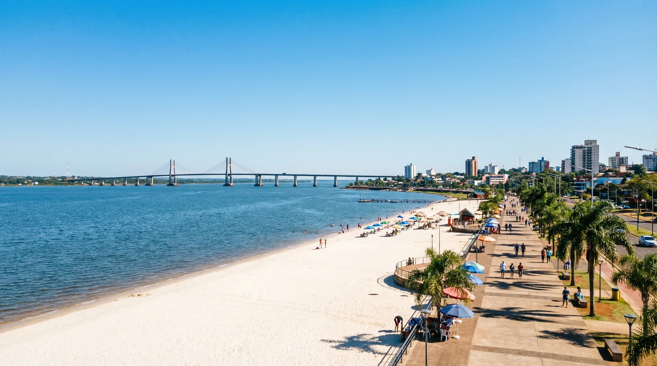 A wide sandy beach and a long cable-stayed bridge crossing a wide river in Encarnación.