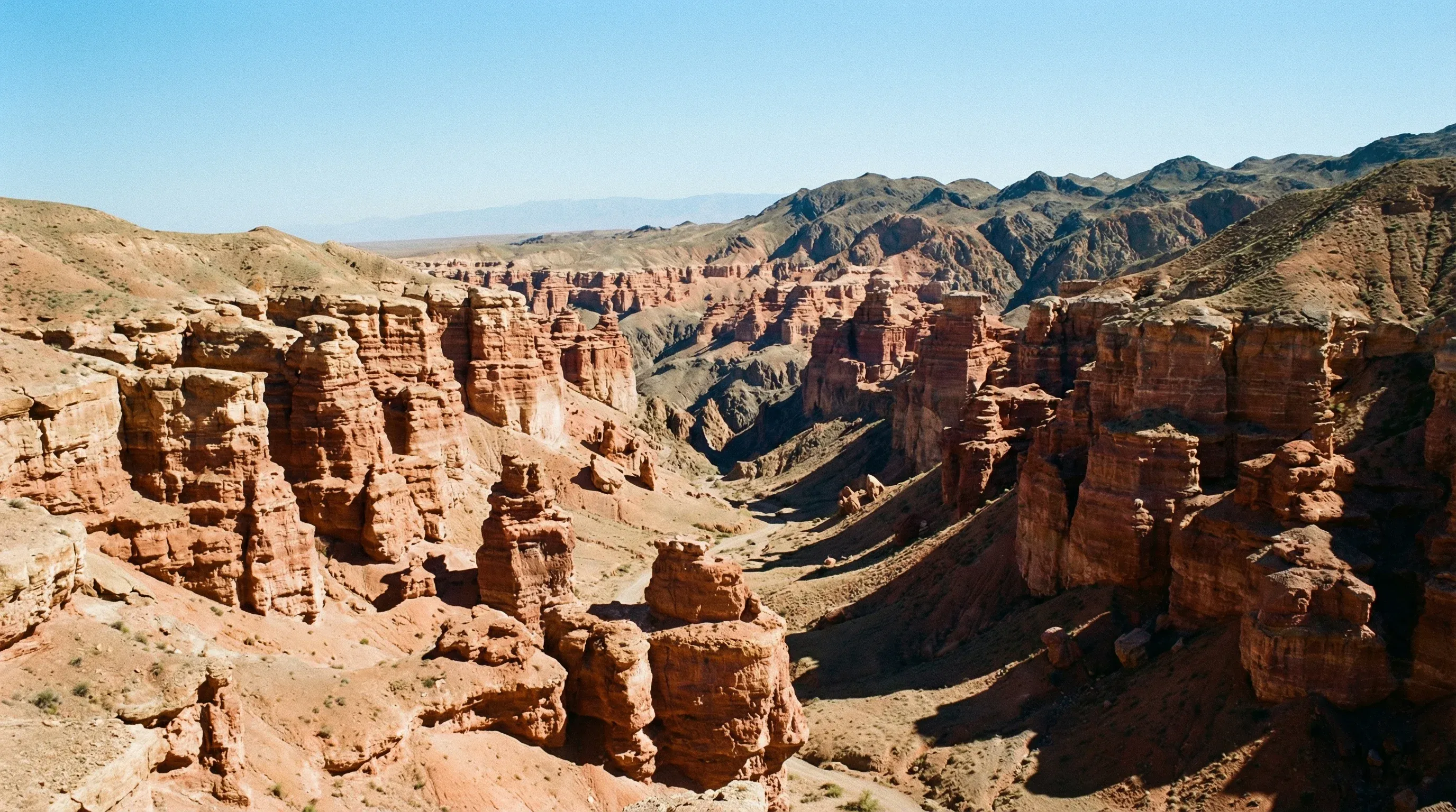 Red sandstone rock formations and deep ravines of the Valley of Castles in Charyn Canyon, Kazakhstan.