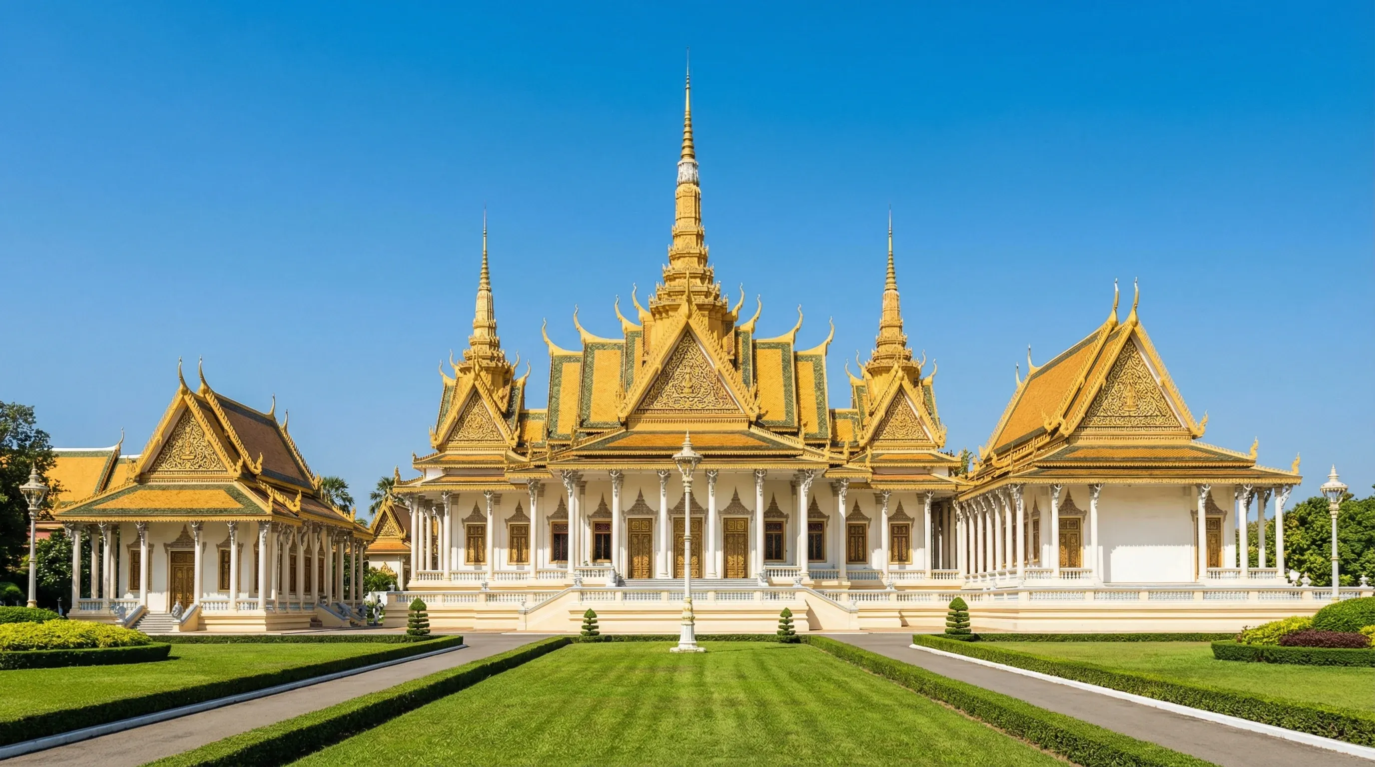 The ornate golden-roofed Throne Hall of the Royal Palace in Phnom Penh under a clear blue sky.