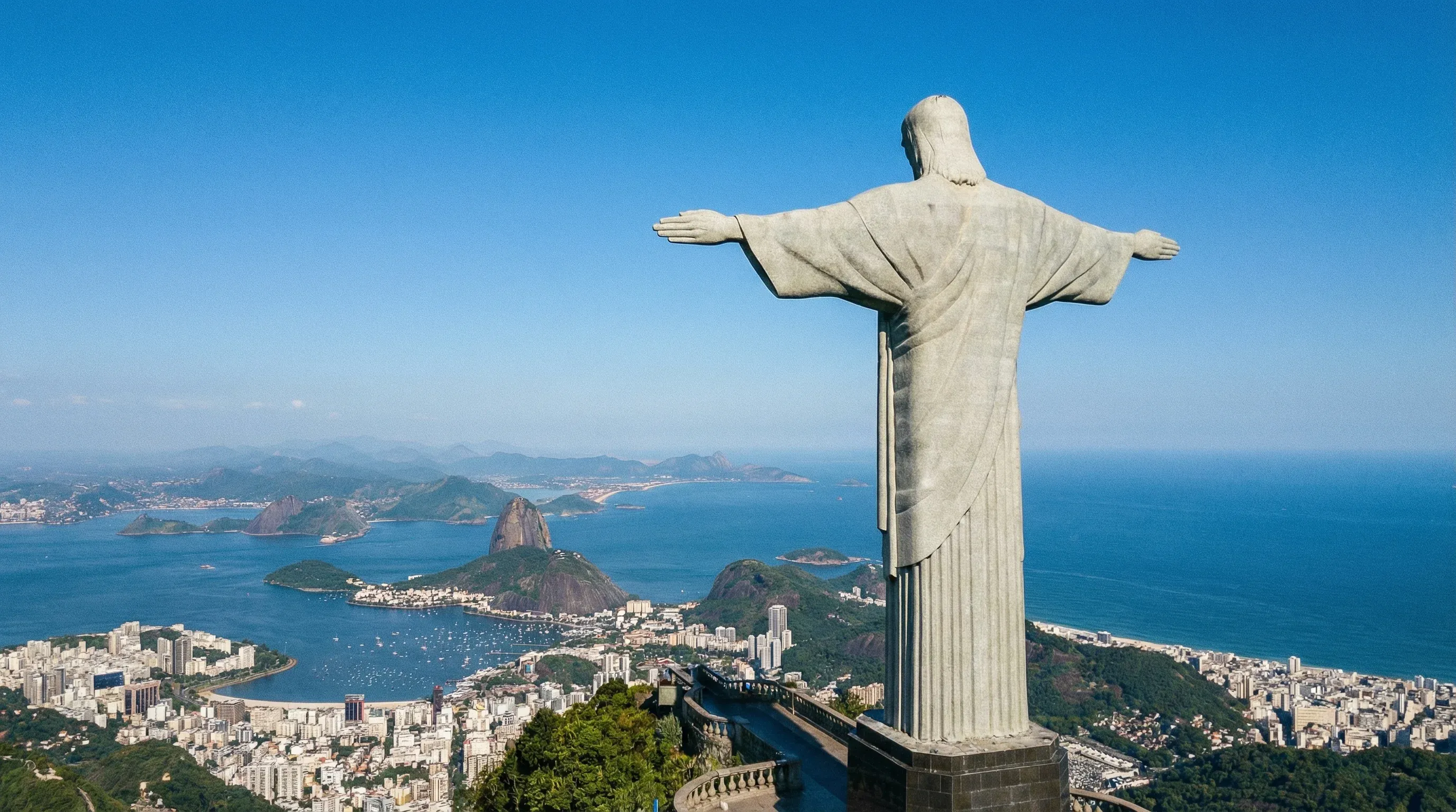 The Christ the Redeemer statue on a mountain peak overlooking the bay and the coastline of Rio de Janeiro.