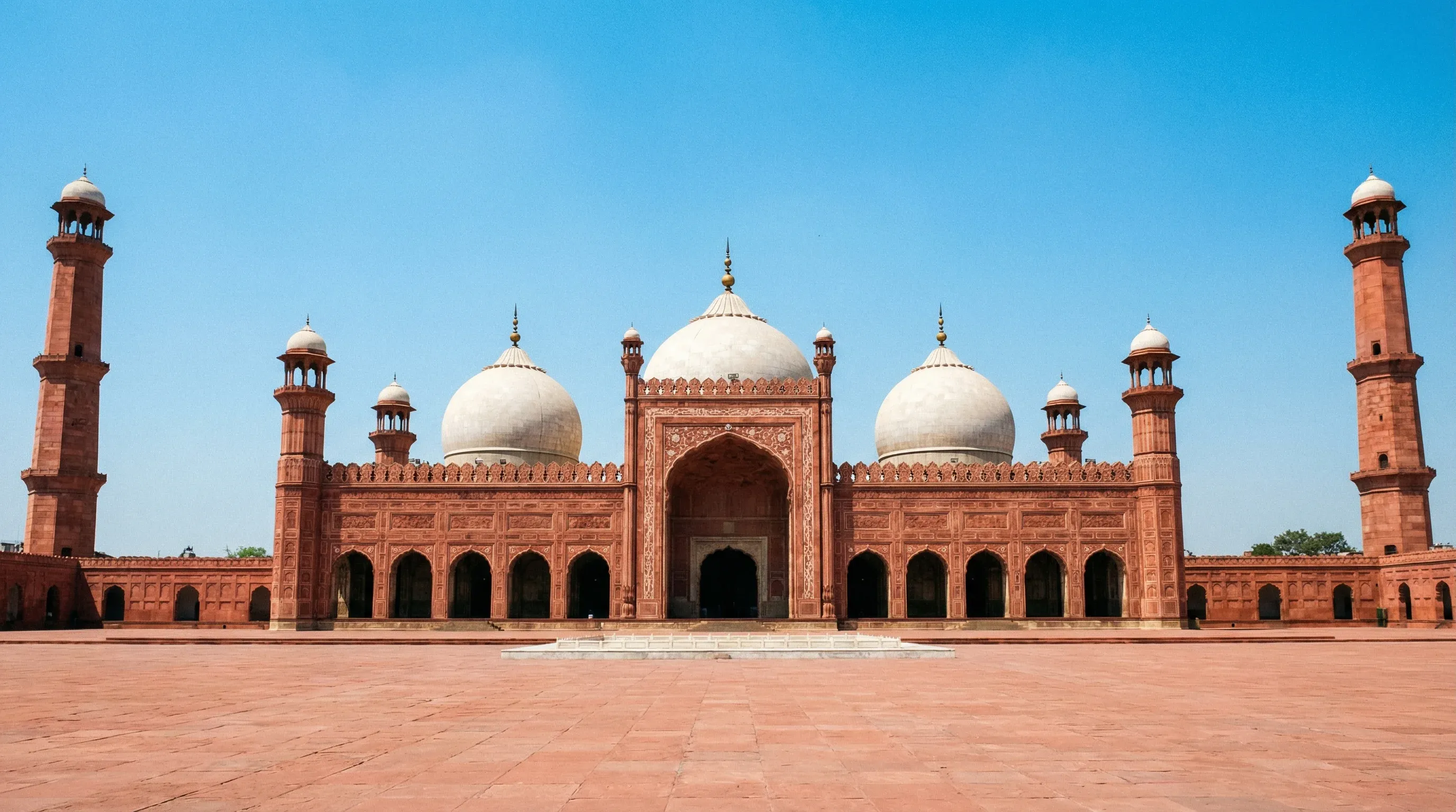 The red sandstone Badshahi Mosque with its iconic white marble domes and minarets in Lahore, Punjab.