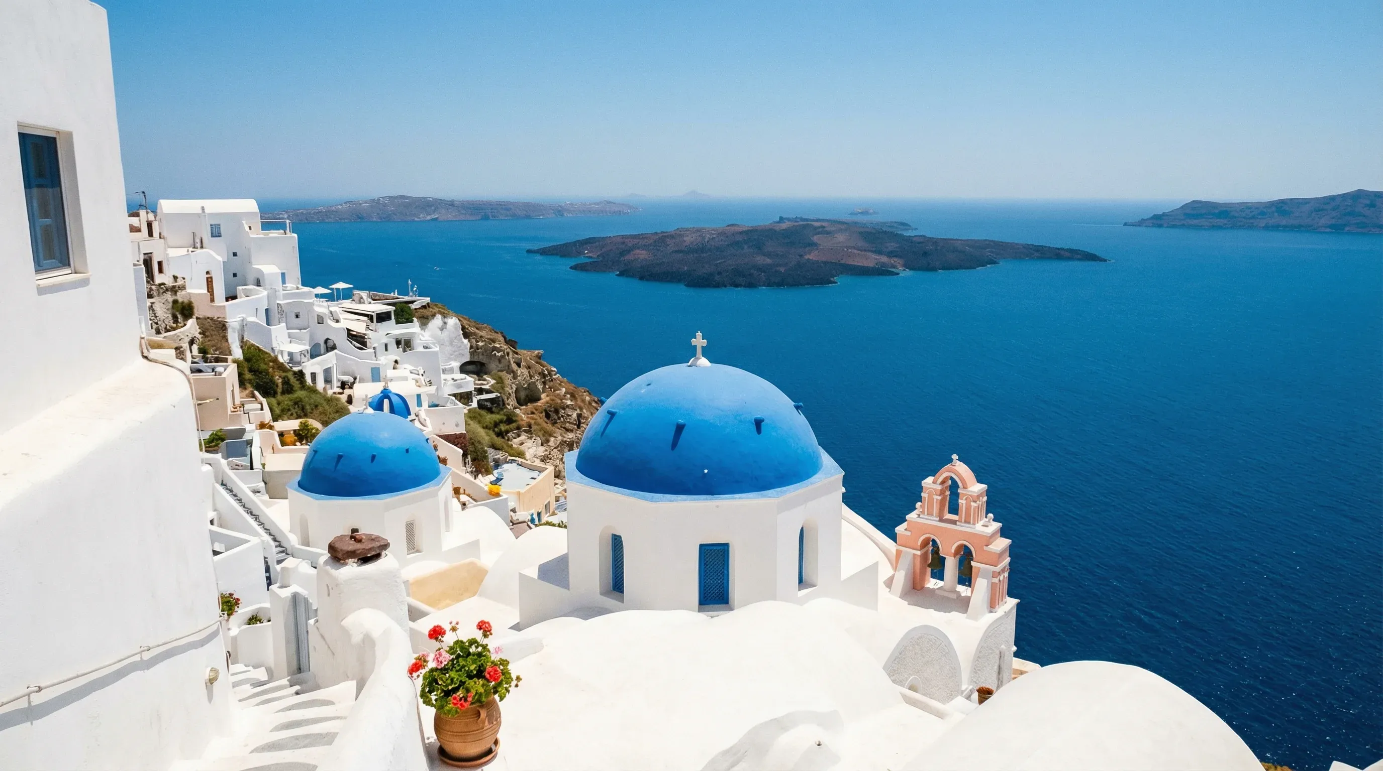 White-washed houses and blue-domed churches overlooking the sea in Oia, Santorini.