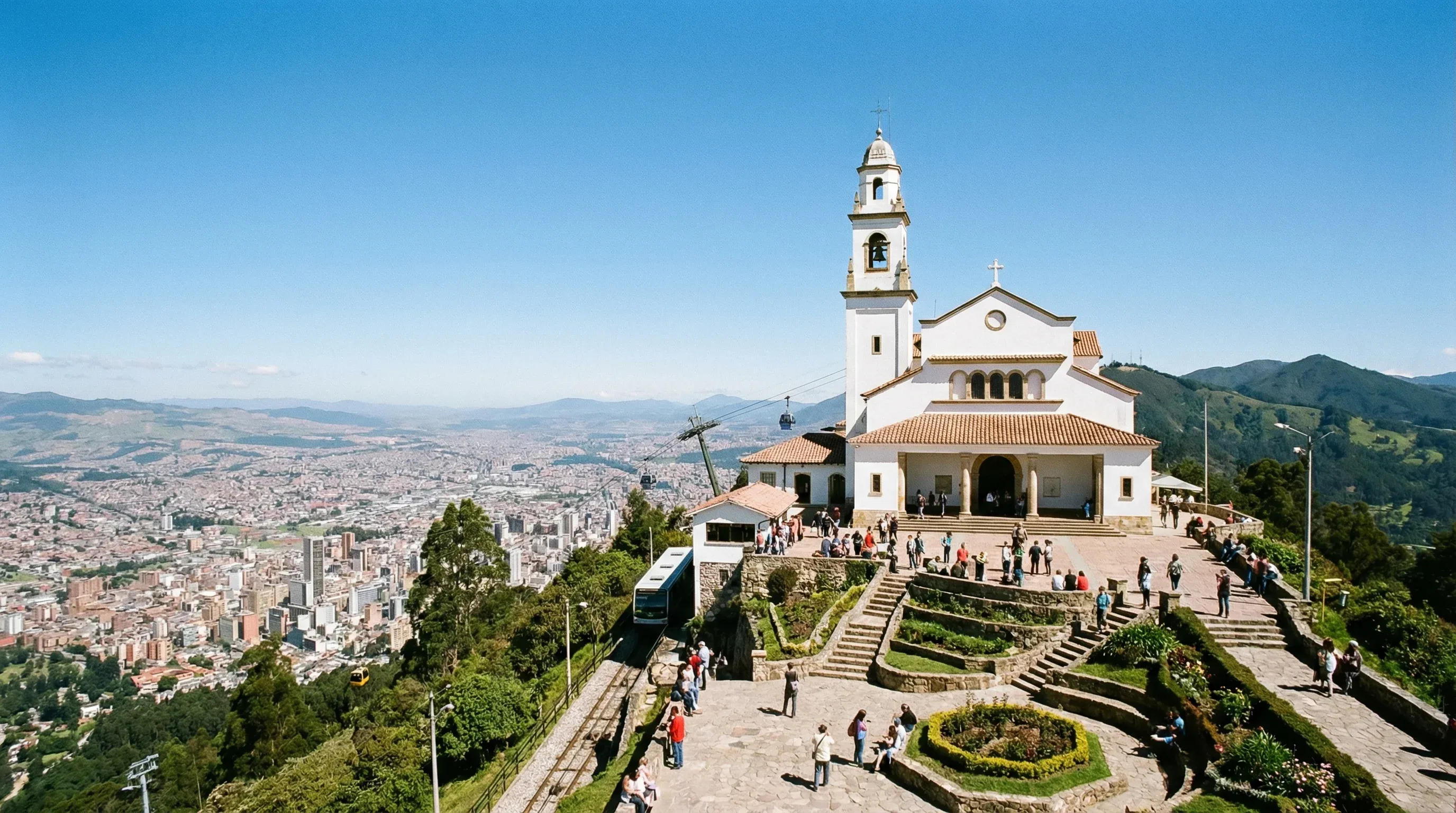 The white Monserrate Sanctuary on a mountain peak overlooking the sprawling city of Bogotá in the valley below.