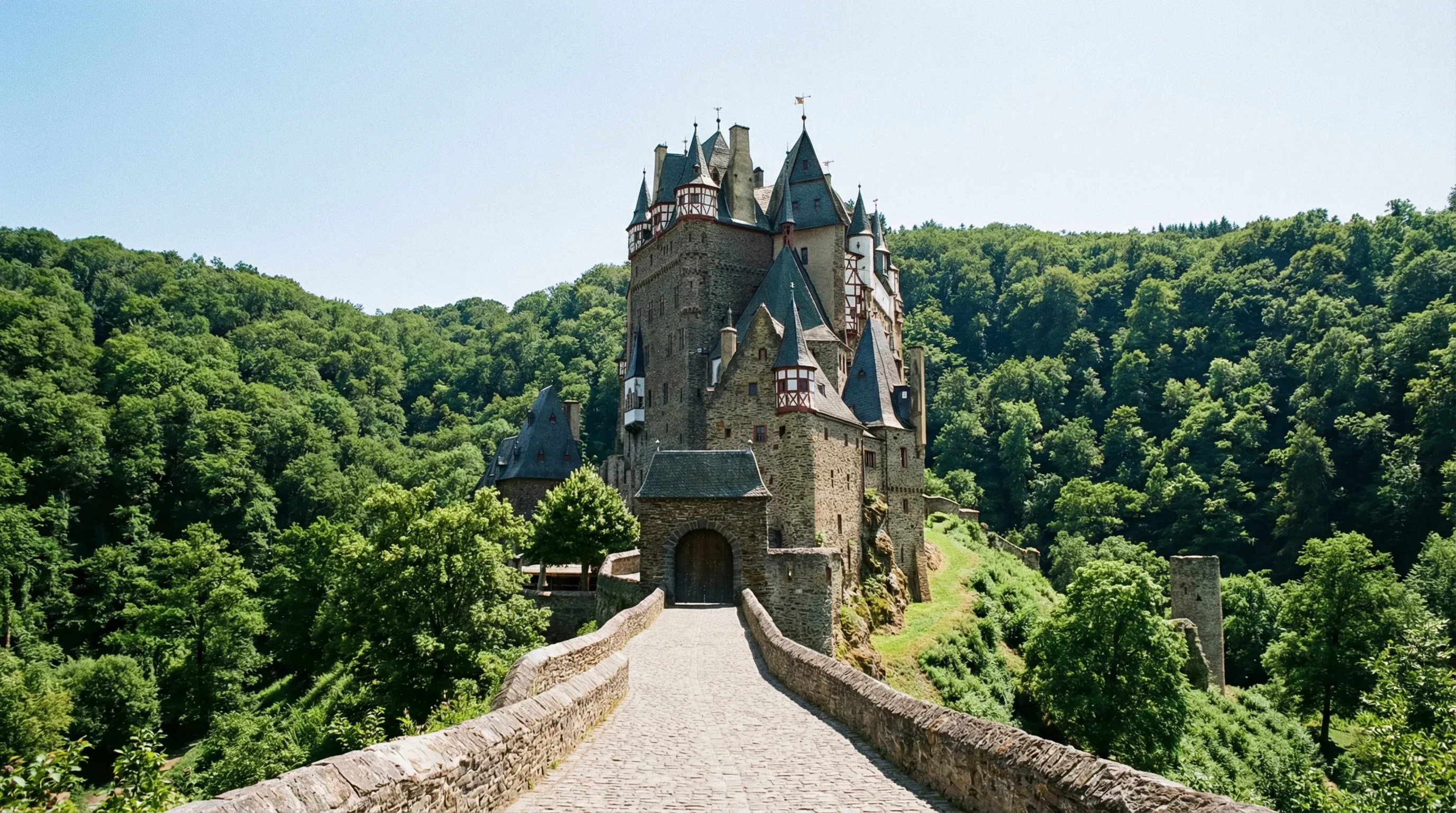 The medieval Burg Eltz castle with its timber-framed towers situated in a deep, forested valley.
