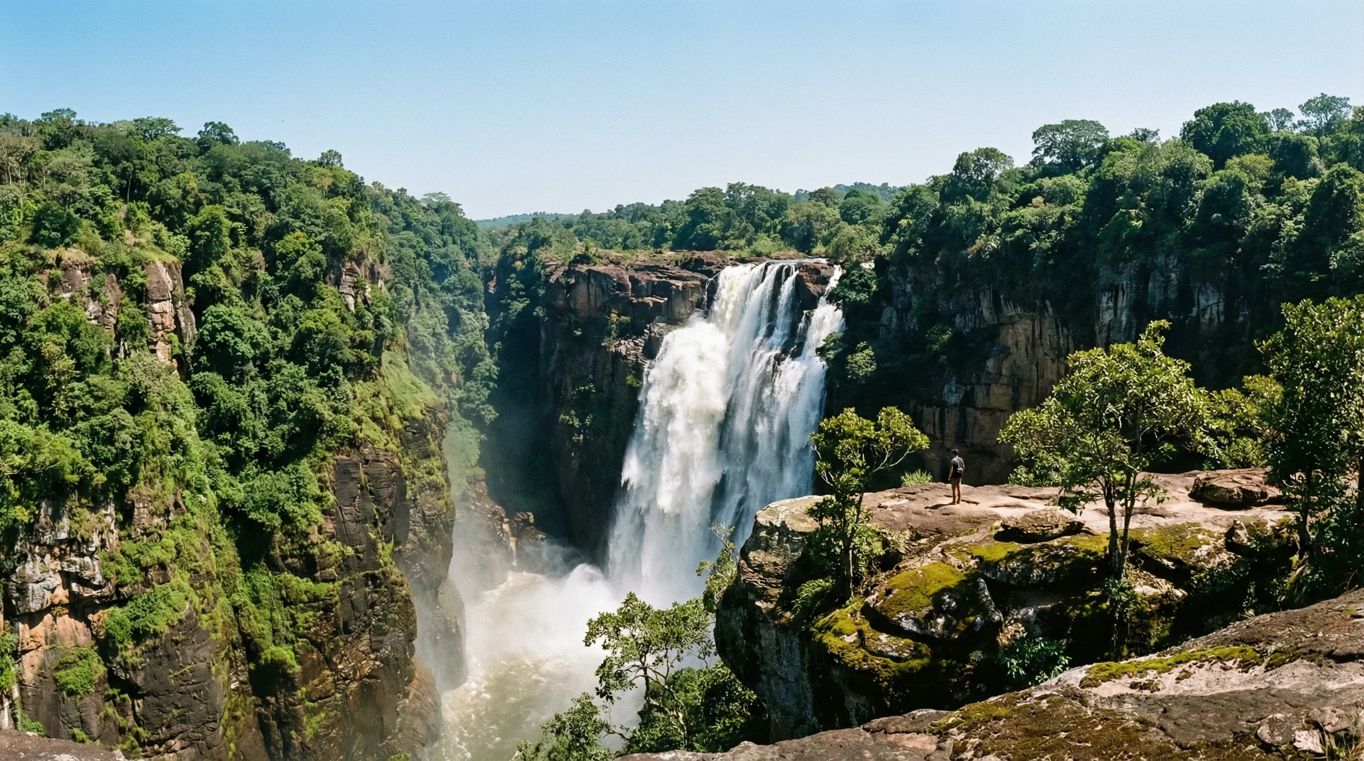 A large waterfall cascading into a deep rocky canyon in the Fouta Djallon highlands.