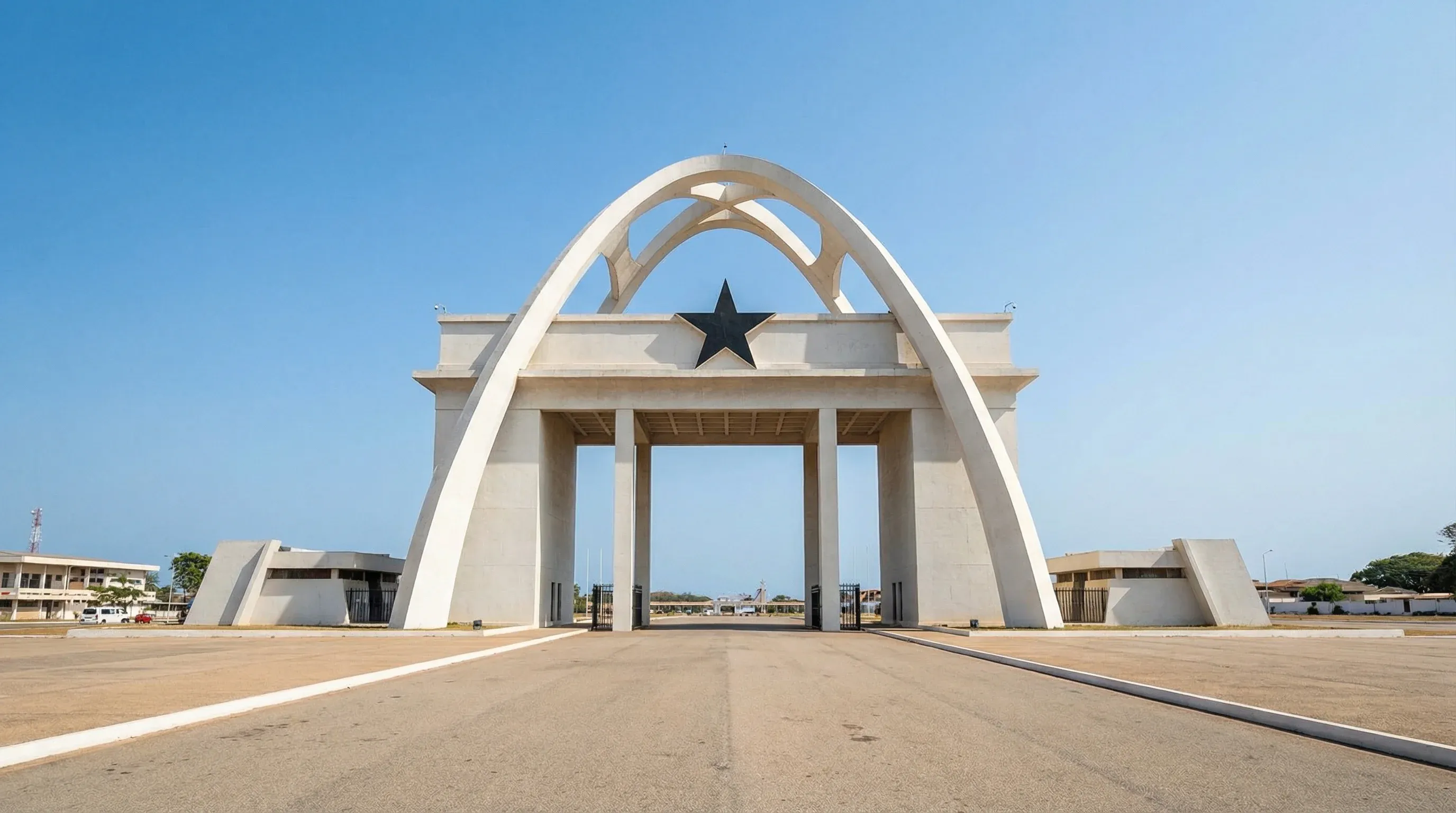 The white Independence Arch at Black Star Square in Accra, Ghana, under a clear blue midday sky.
