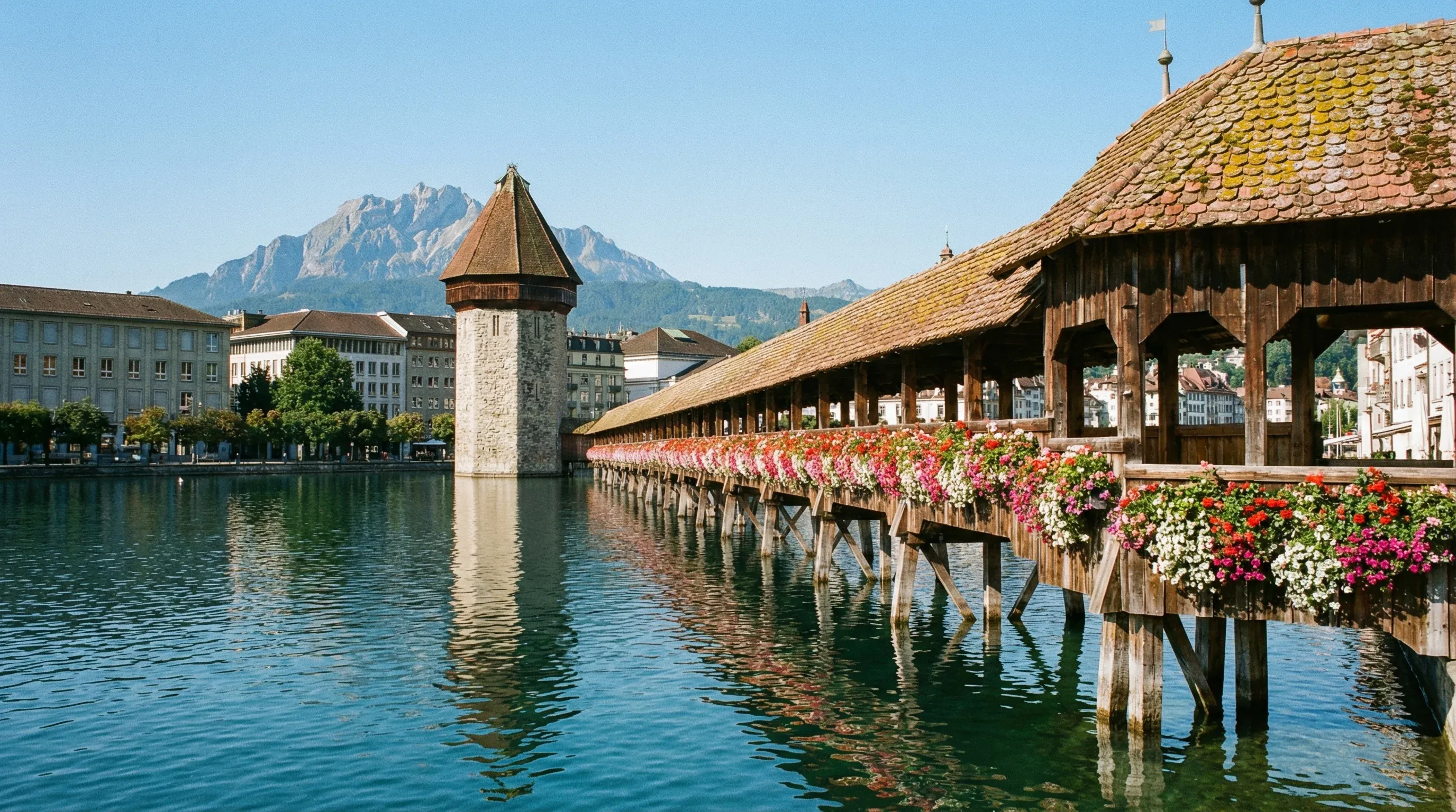 The wooden Chapel Bridge and stone Water Tower on the Reuss River in Lucerne, Switzerland.