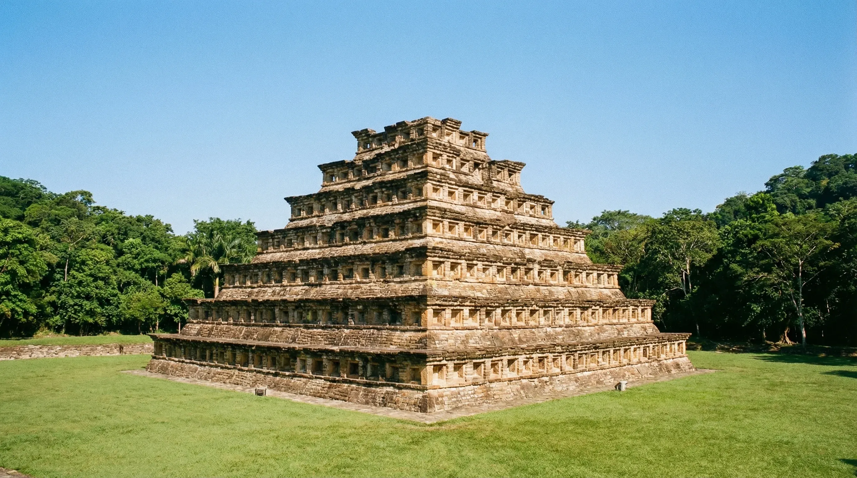 An ancient Totonac stone pyramid with hundreds of symmetrical niches surrounded by tropical forest in Veracruz.