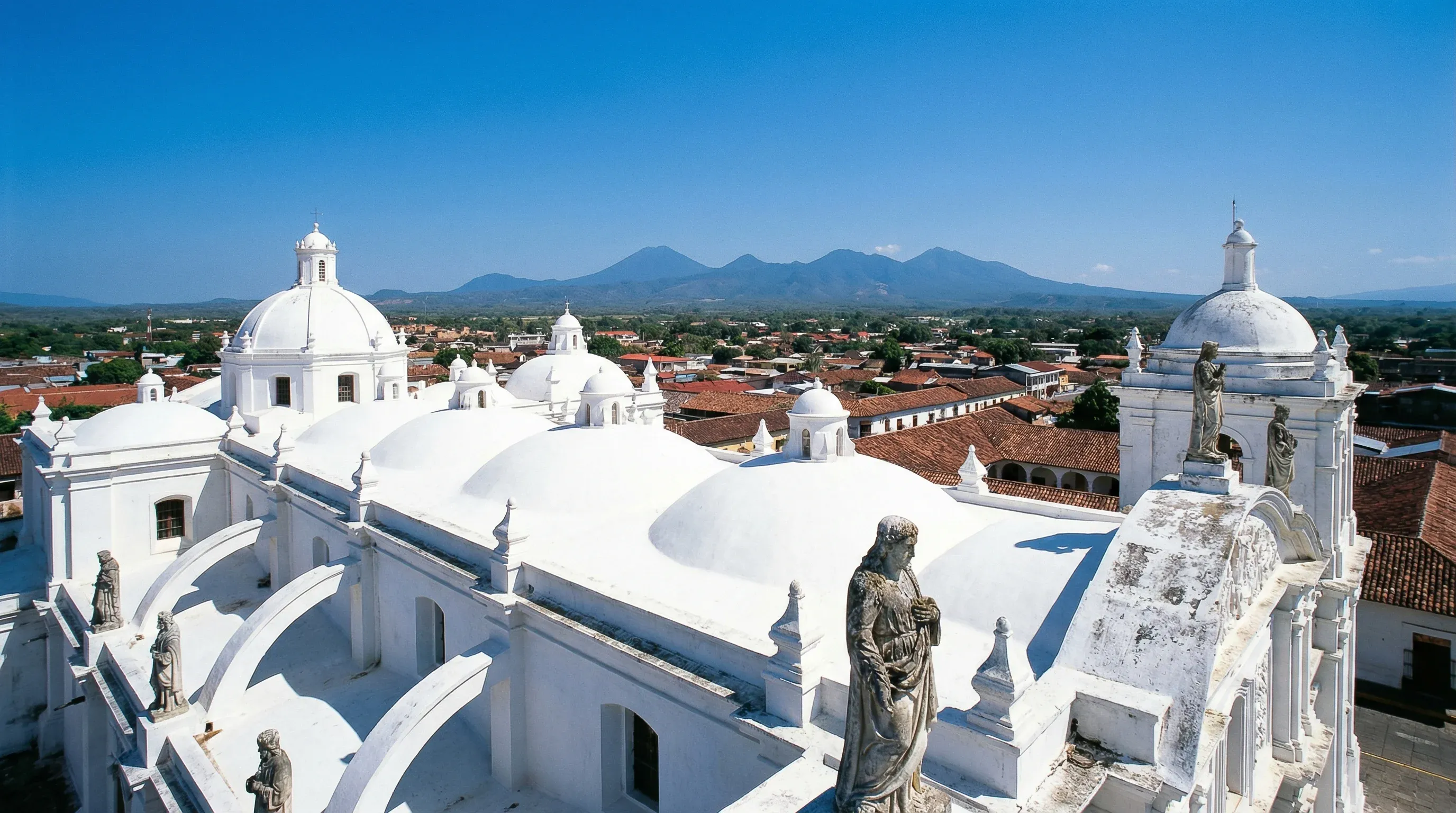 The white domes on the roof of the Cathedral of León overlooking the city toward distant volcanoes.