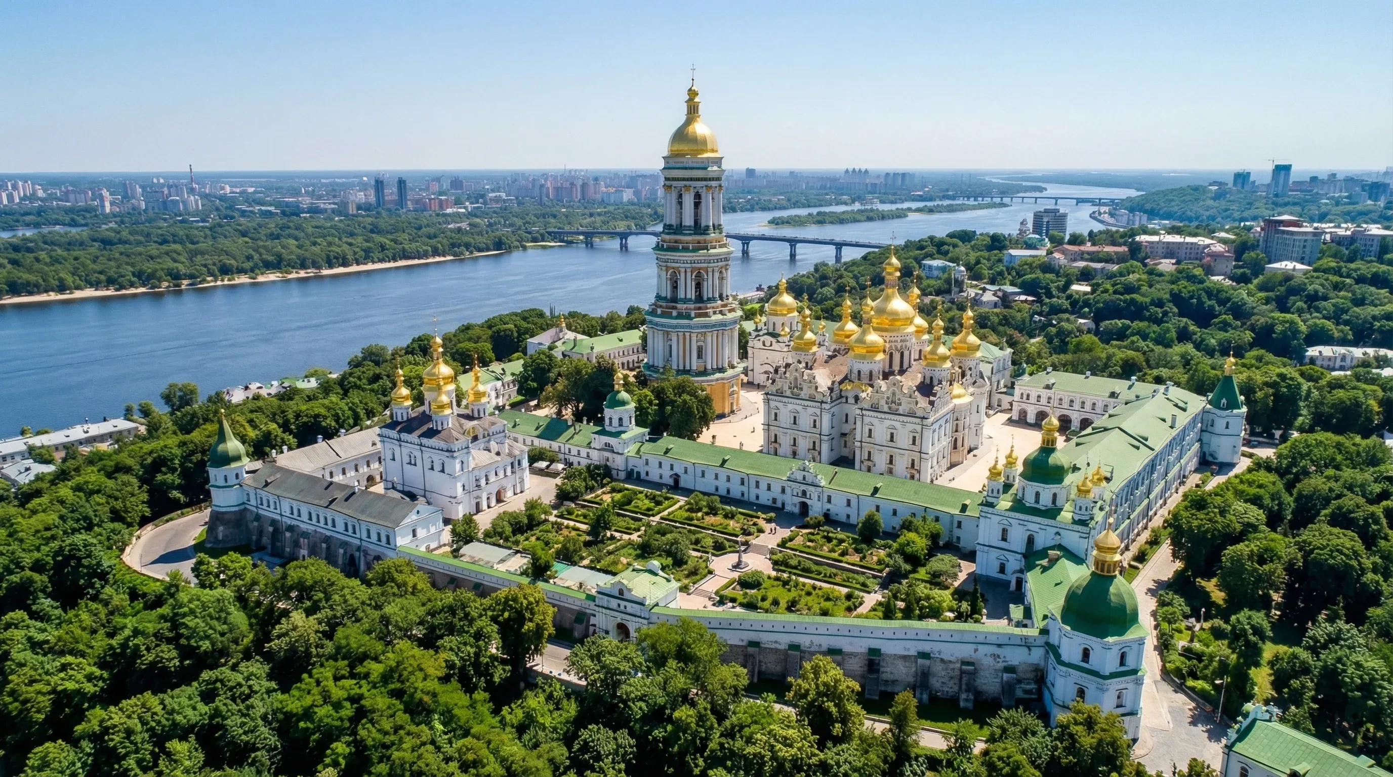 The gold-domed churches and bell tower of the Kyiv Pechersk Lavra monastery on a hill above the Dnipro River.