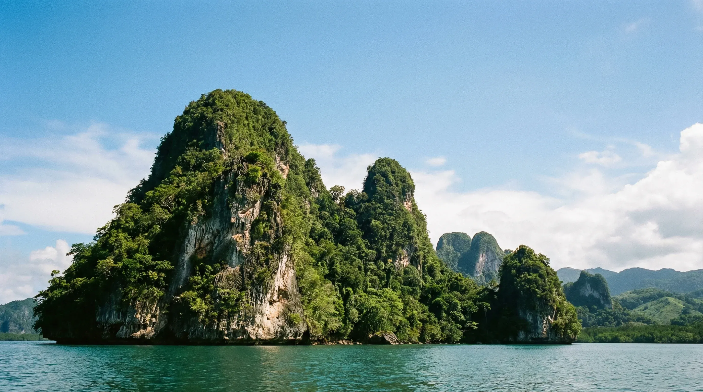 Forested limestone karst islands rising from the turquoise waters of Los Haitises National Park in Samaná Bay.