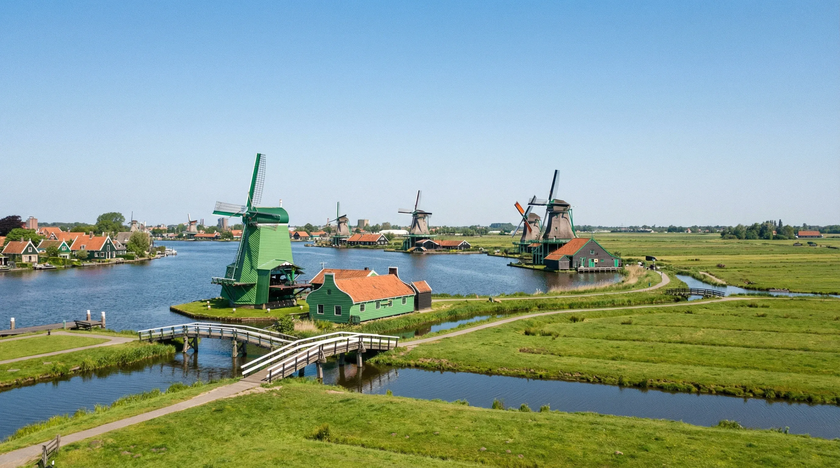 Traditional green wooden windmills lining the Zaan river at Zaanse Schans in North Holland.