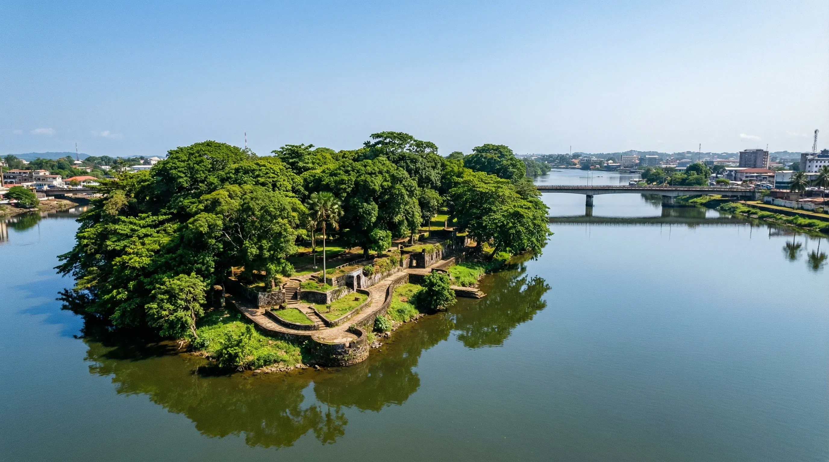 An aerial-style view of the historic Providence Island and the Gabriel Tucker Bridge in the Mesurado River under a clear sky.