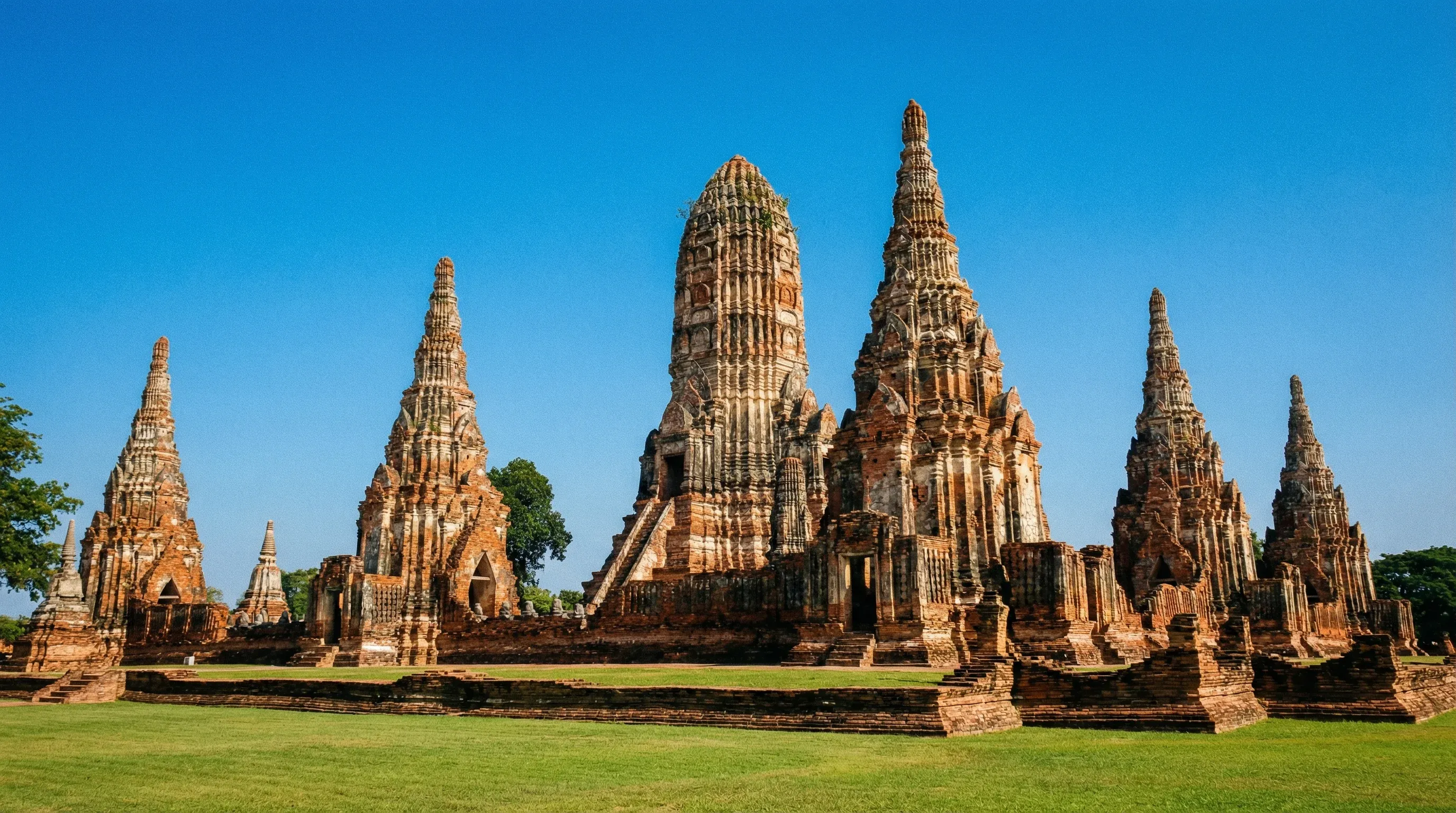 Ancient brick ruins of Wat Chaiwatthanaram temple in Ayutthaya Historical Park seen from a wide angle.