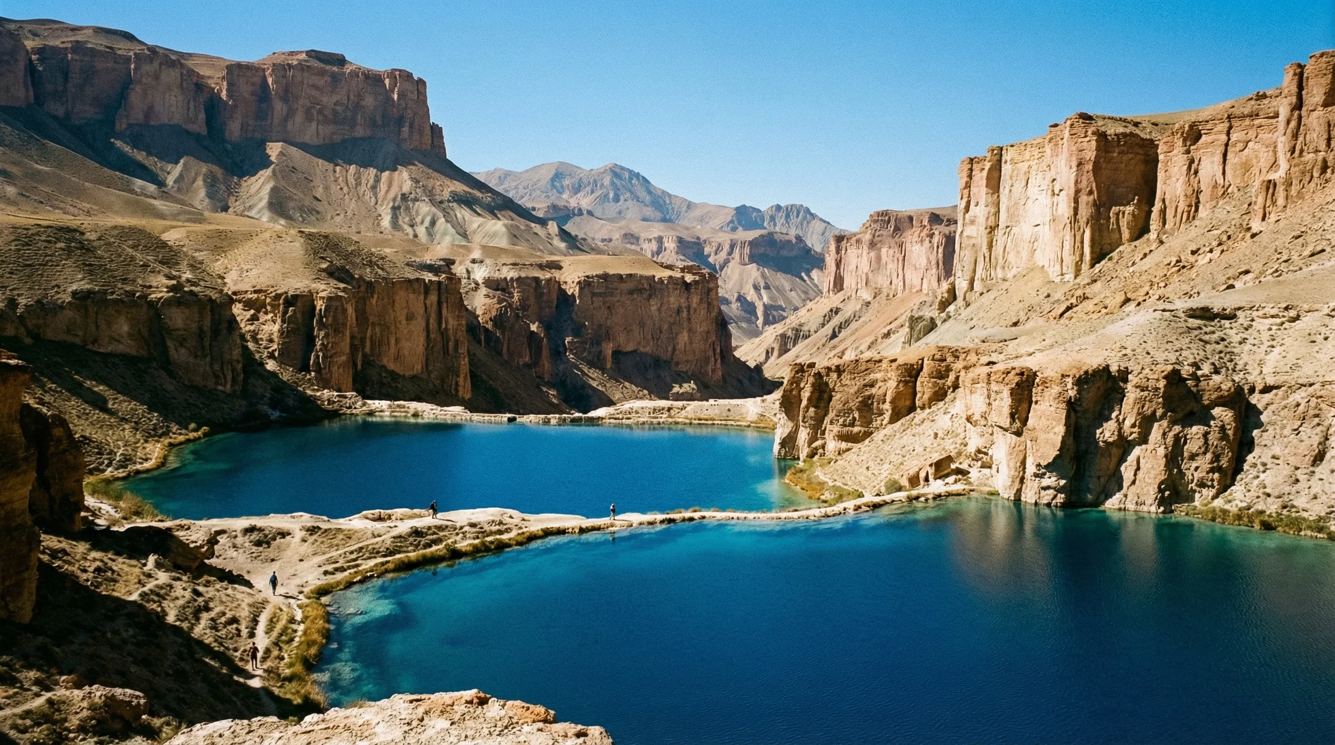 Deep blue alpine lakes surrounded by high limestone cliffs in Band-e-Amir National Park under a clear sky.