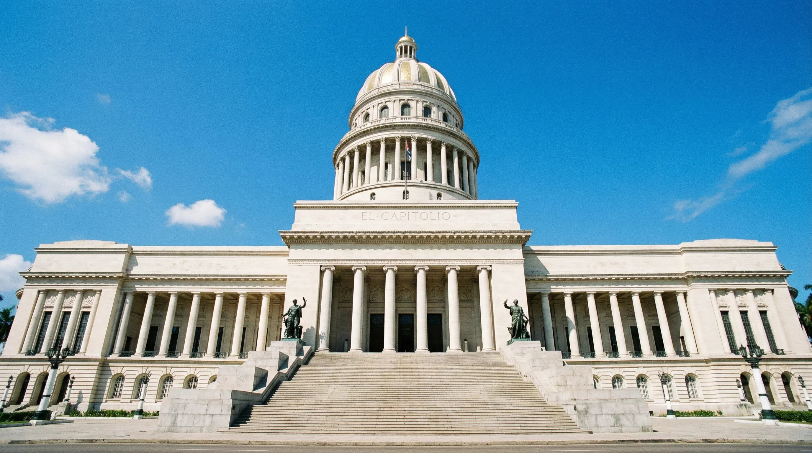 The neoclassical facade and dome of El Capitolio building in Havana, Cuba, under a bright midday sun.